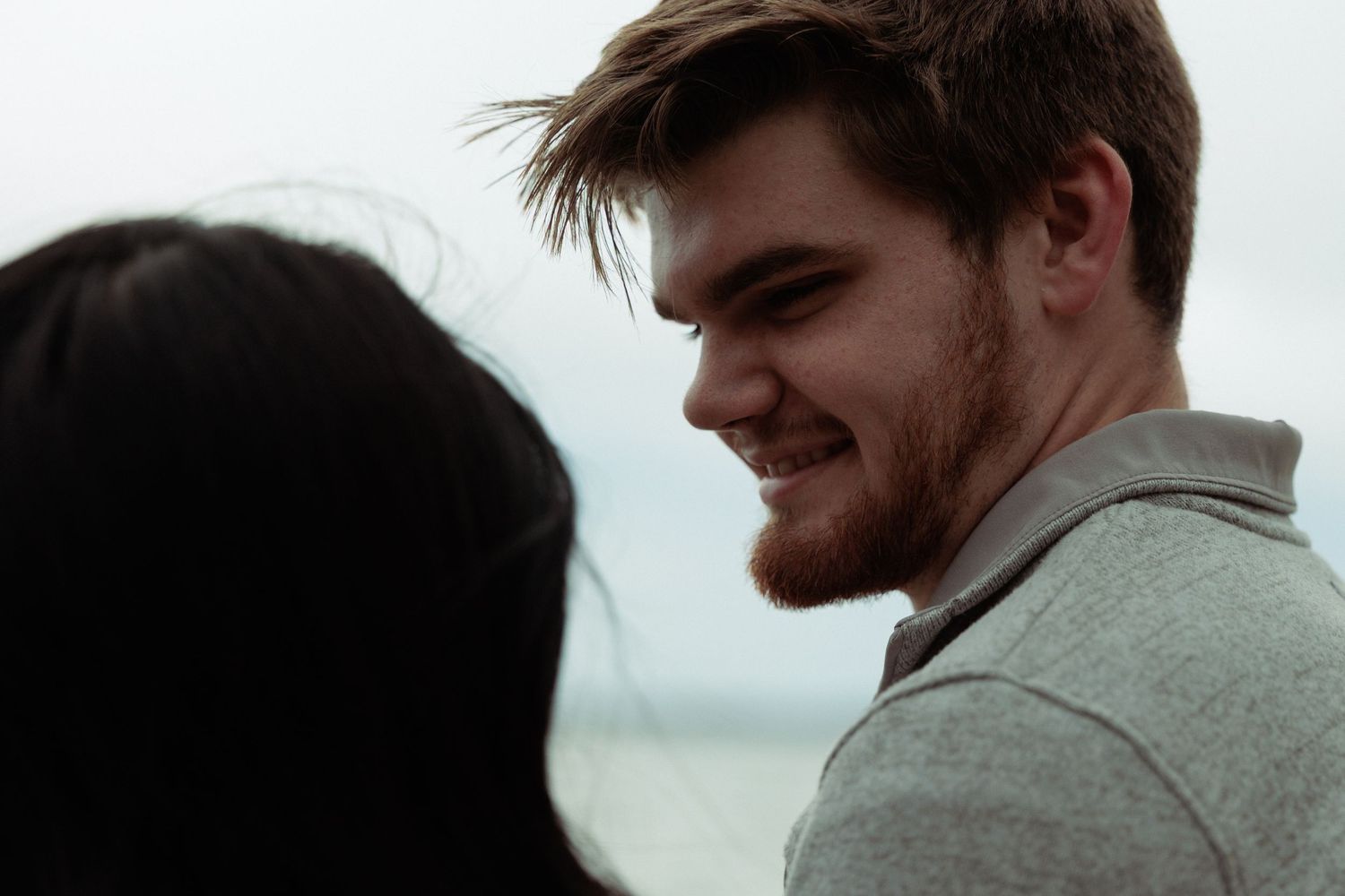 A close-up candid moment captured by the water on an overcast day.