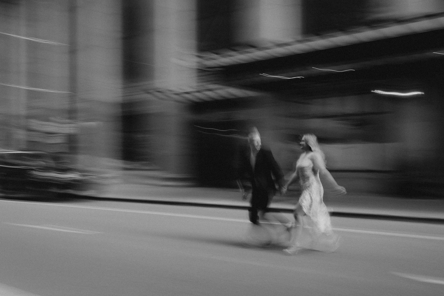 Motion blur street photography of wedding party walking through urban setting.