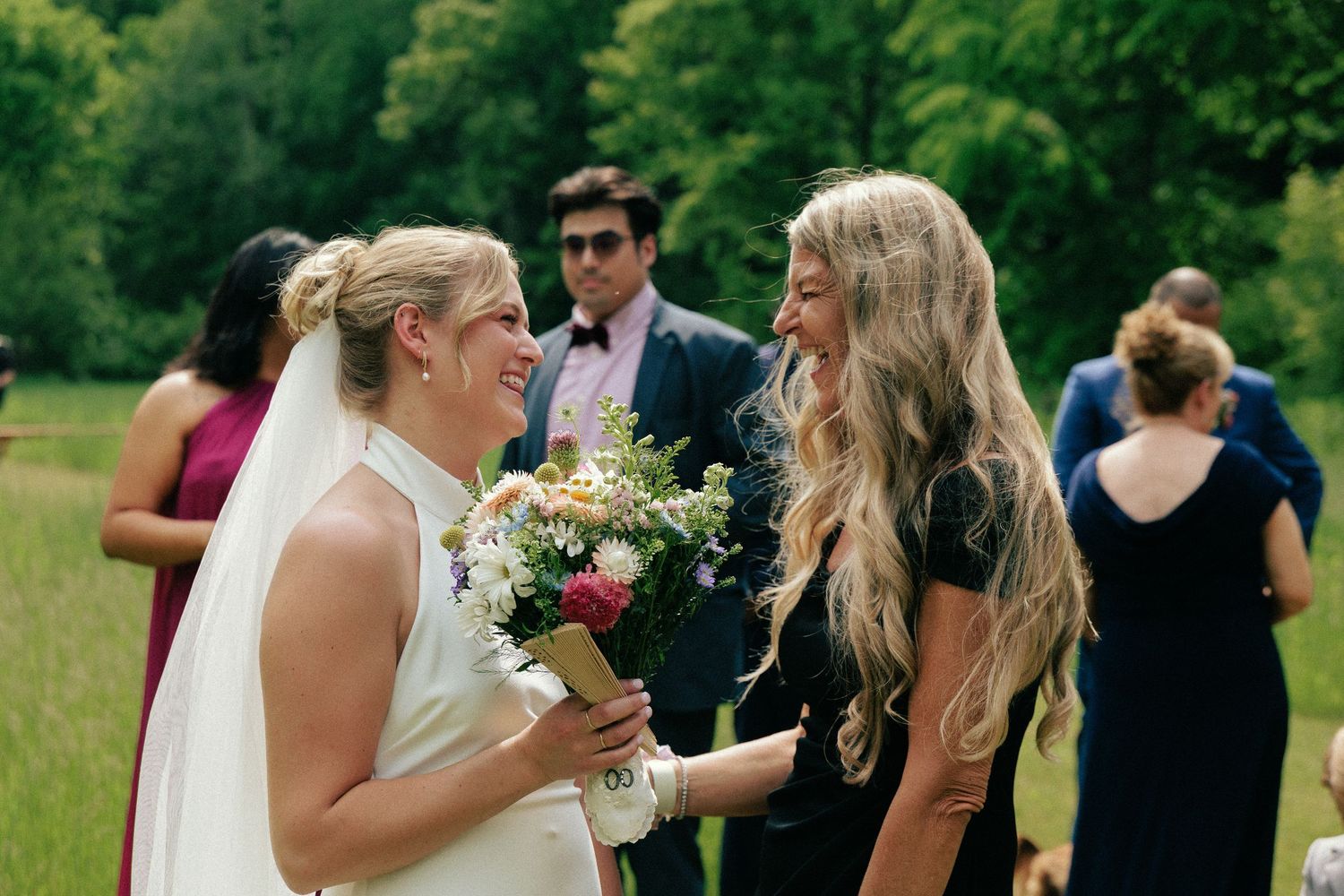 Wedding guests mingling and celebrating in an outdoor garden setting.