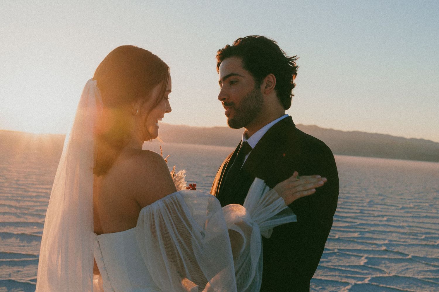 Romantic sunset wedding portrait with utah salt flats and mountains in background.