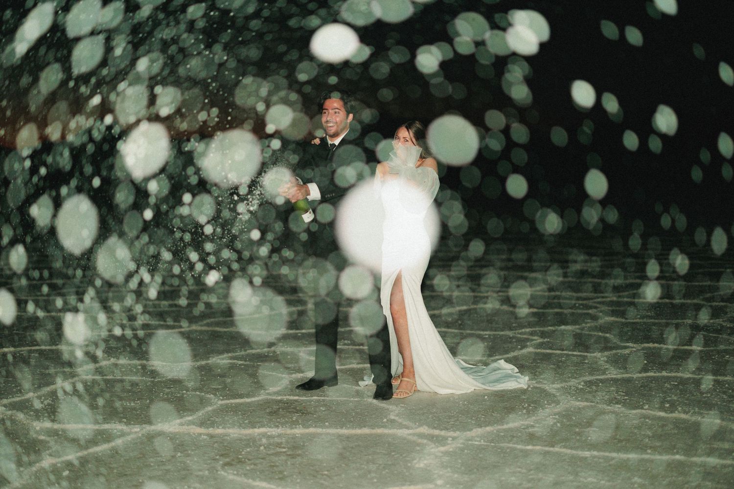 Wedding photo with dreamy bokeh lights creating a magical nighttime atmosphere.