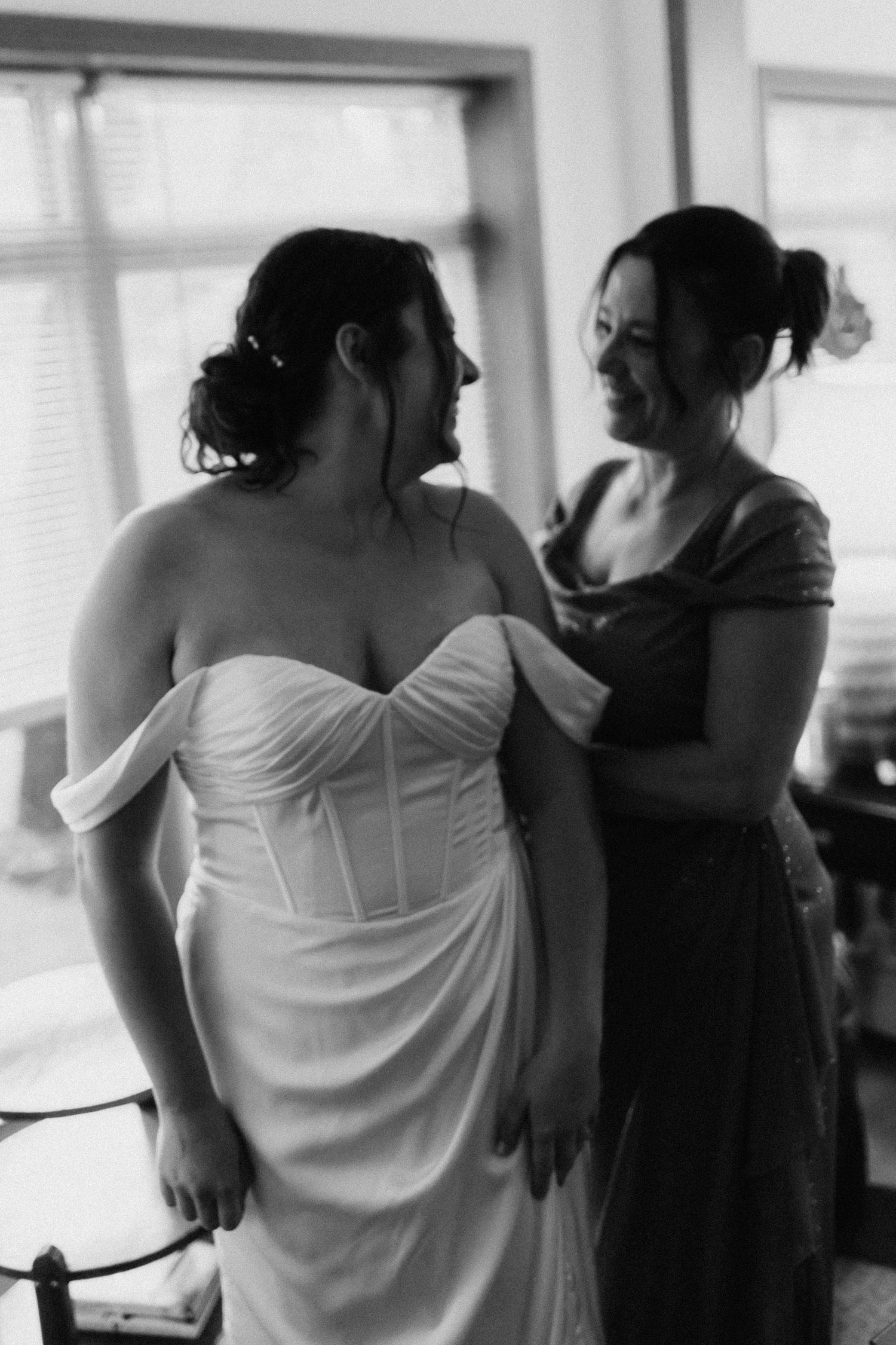 Wedding preparation scene with people getting dressed in soft black and white tones.
