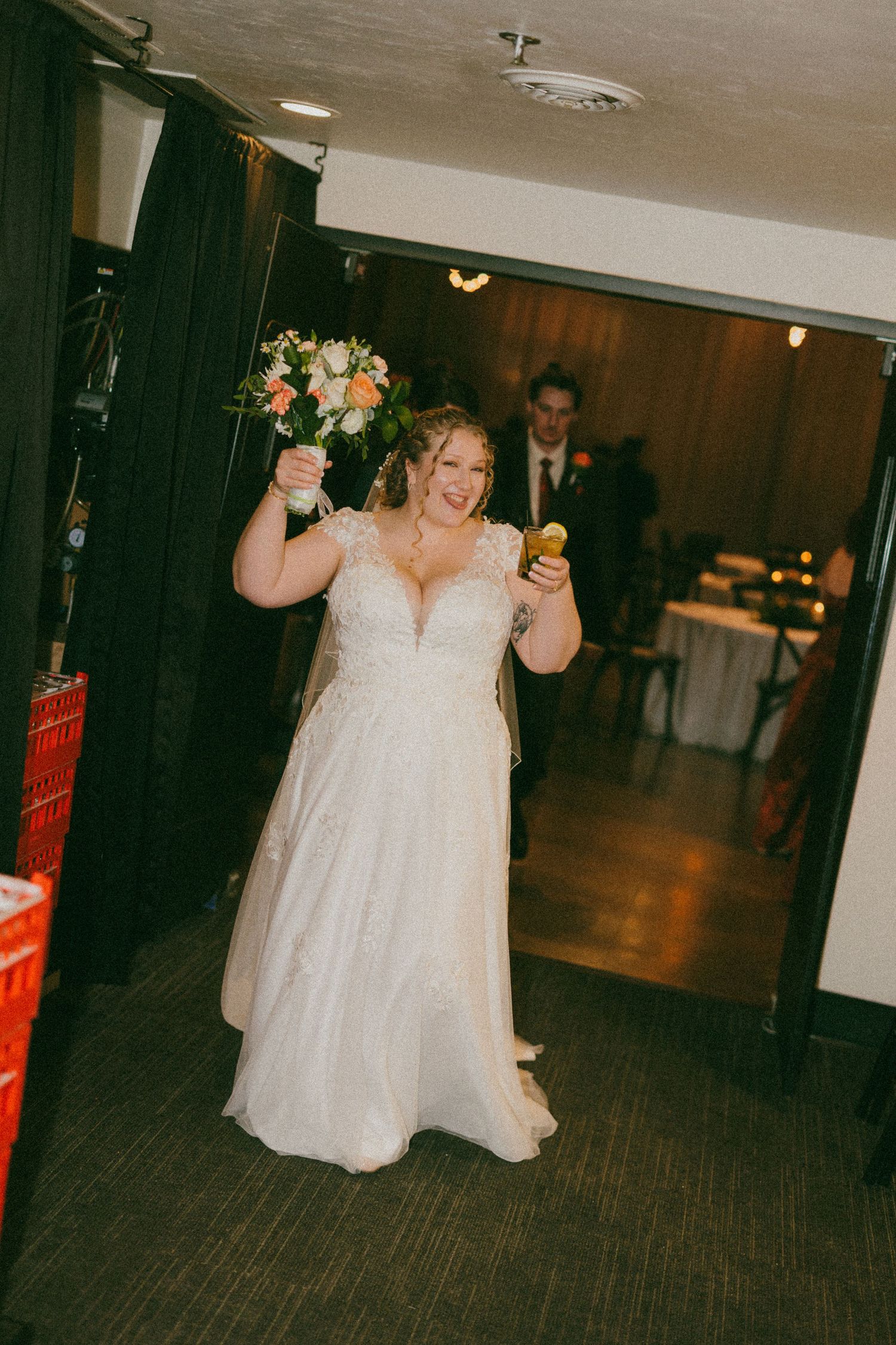 A bride in a flowing white dress dances and celebrates during the wedding reception.