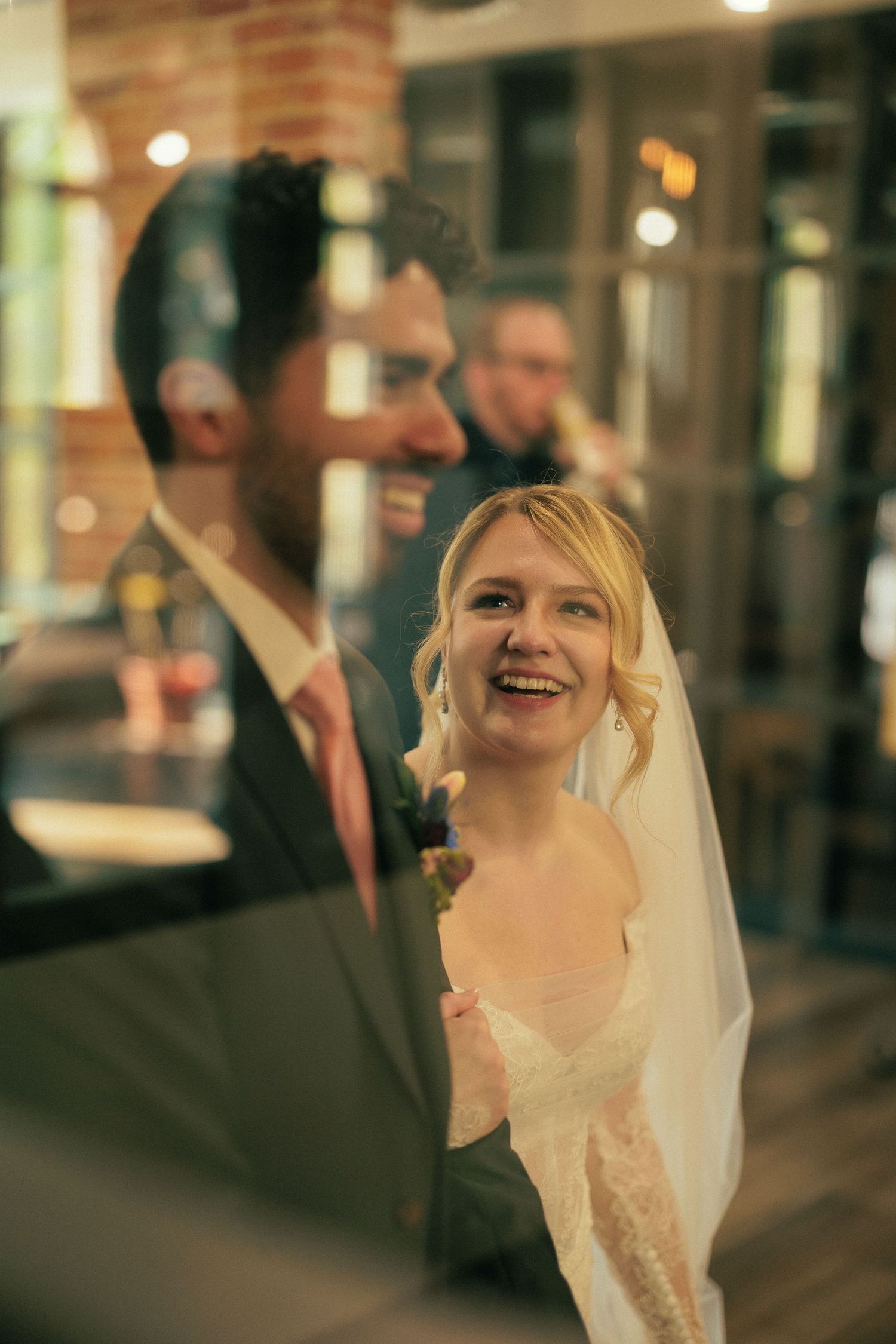 Candid wedding moments captured in warm evening light against brick architecture.