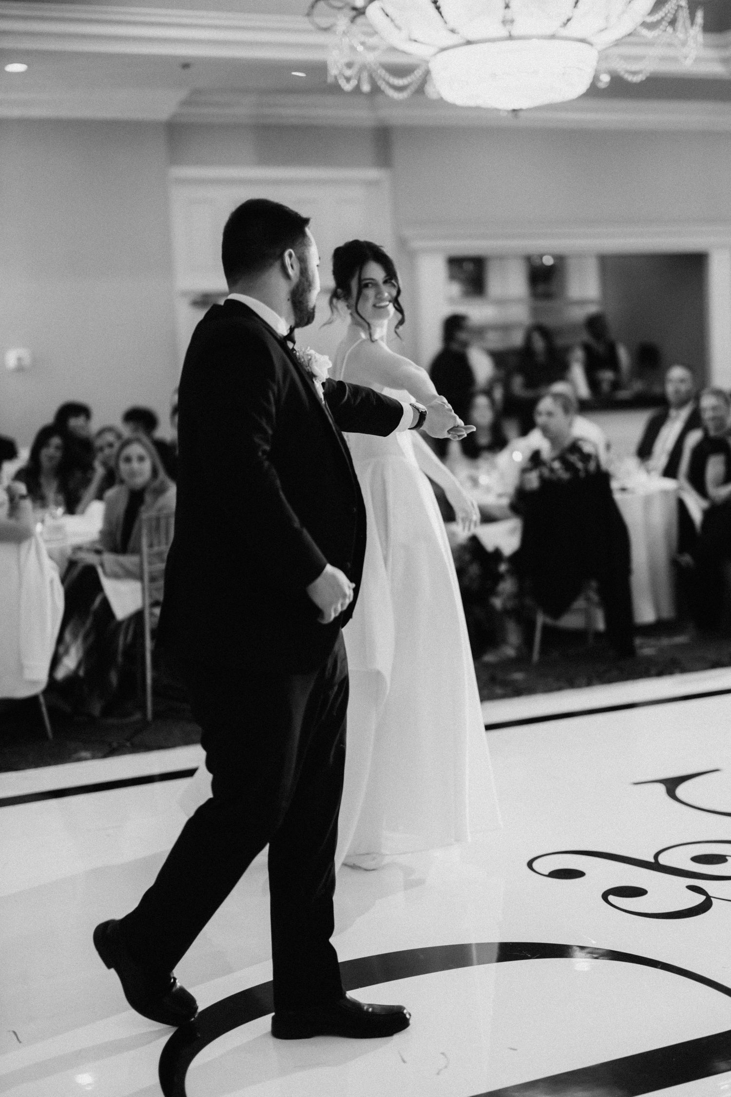 Black and white dance sequence showing a couple performing elegant dance moves at a wedding reception.