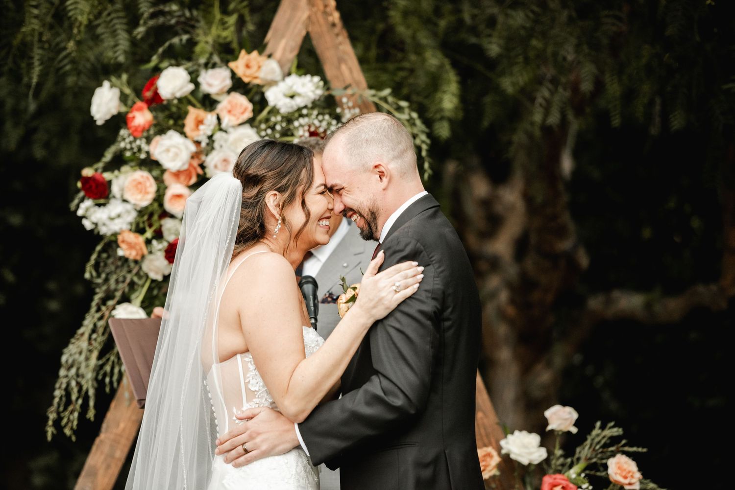 A romantic wedding moment captured in a series of black and white photographs showing tender embraces and floral decor.