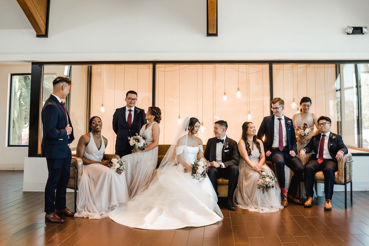 Wedding party seated in modern venue during celebration.