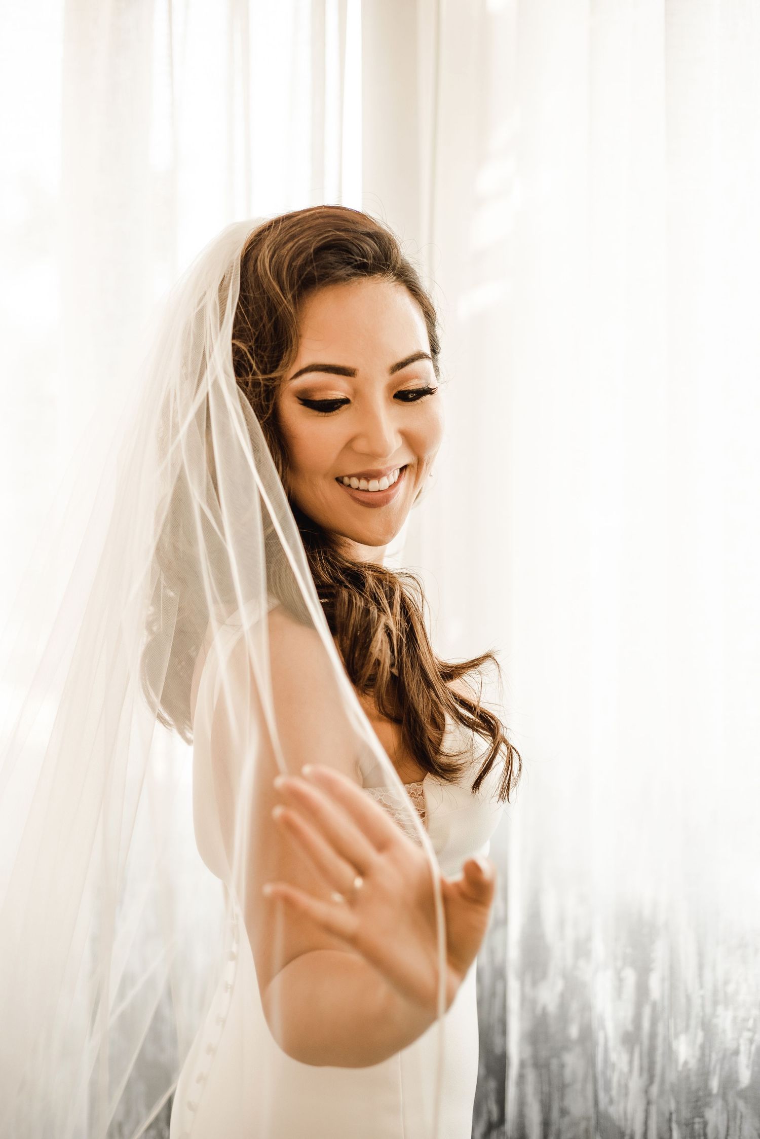 Ethereal bridal portraits with soft window lighting and flowing veil.