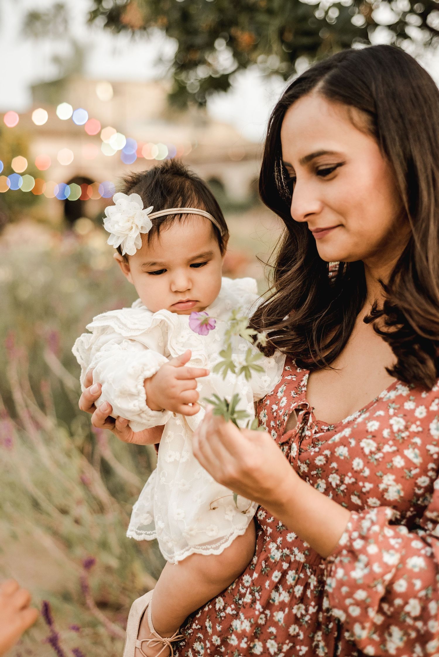 A tender moment captured outdoors with soft bokeh lights in the background.