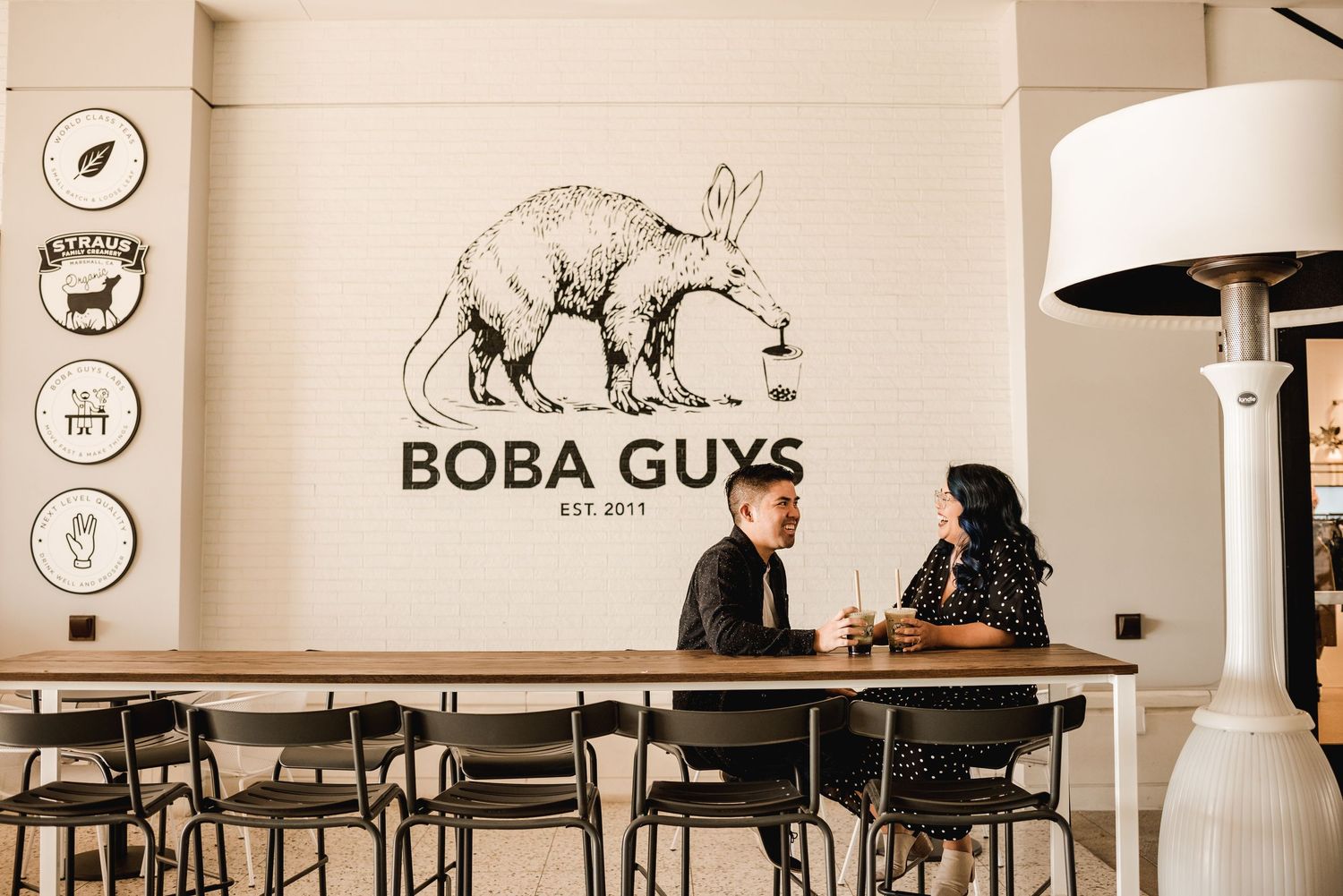 Interior view of modern cafe with minimalist decor and bear logo on wall.