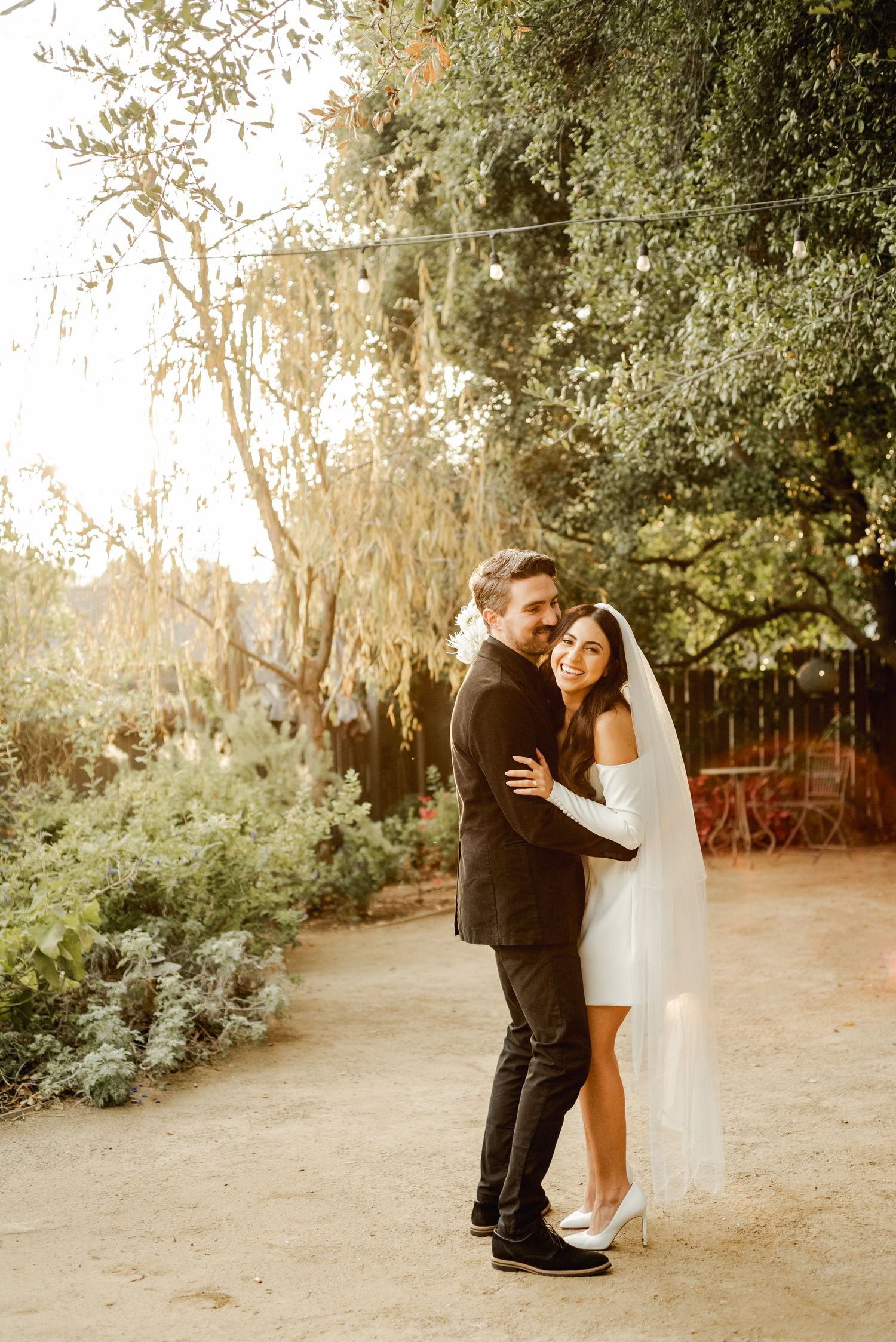 Garden wedding portraits under hanging foliage with natural lighting.