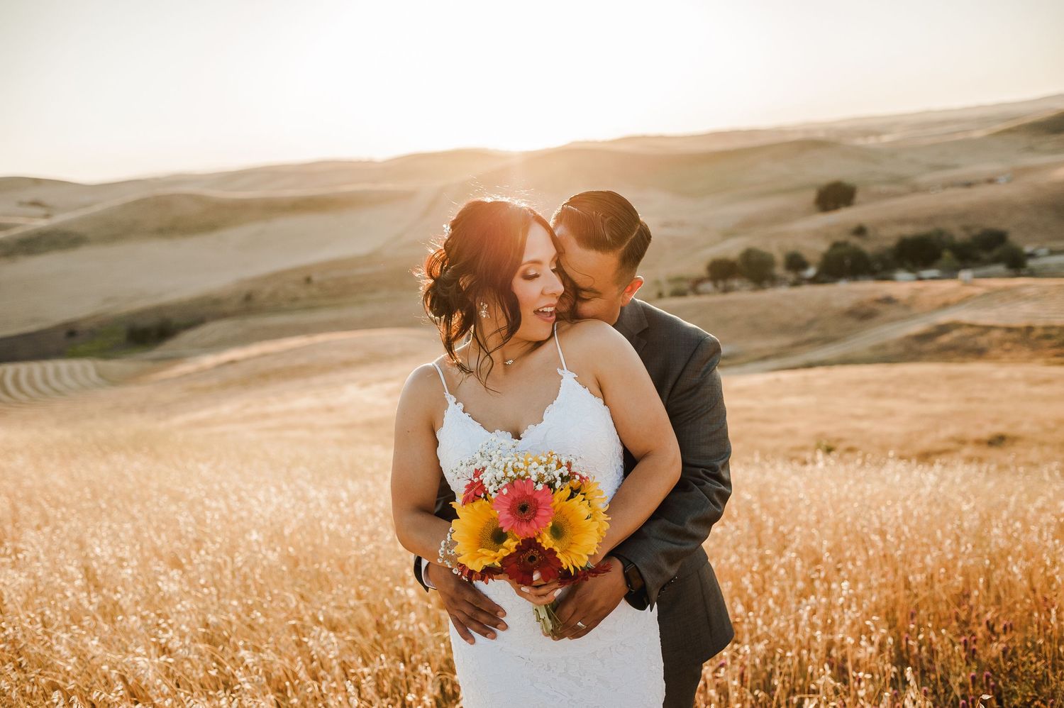 Golden hour wedding photos in a sunlit wheat field with romantic poses.