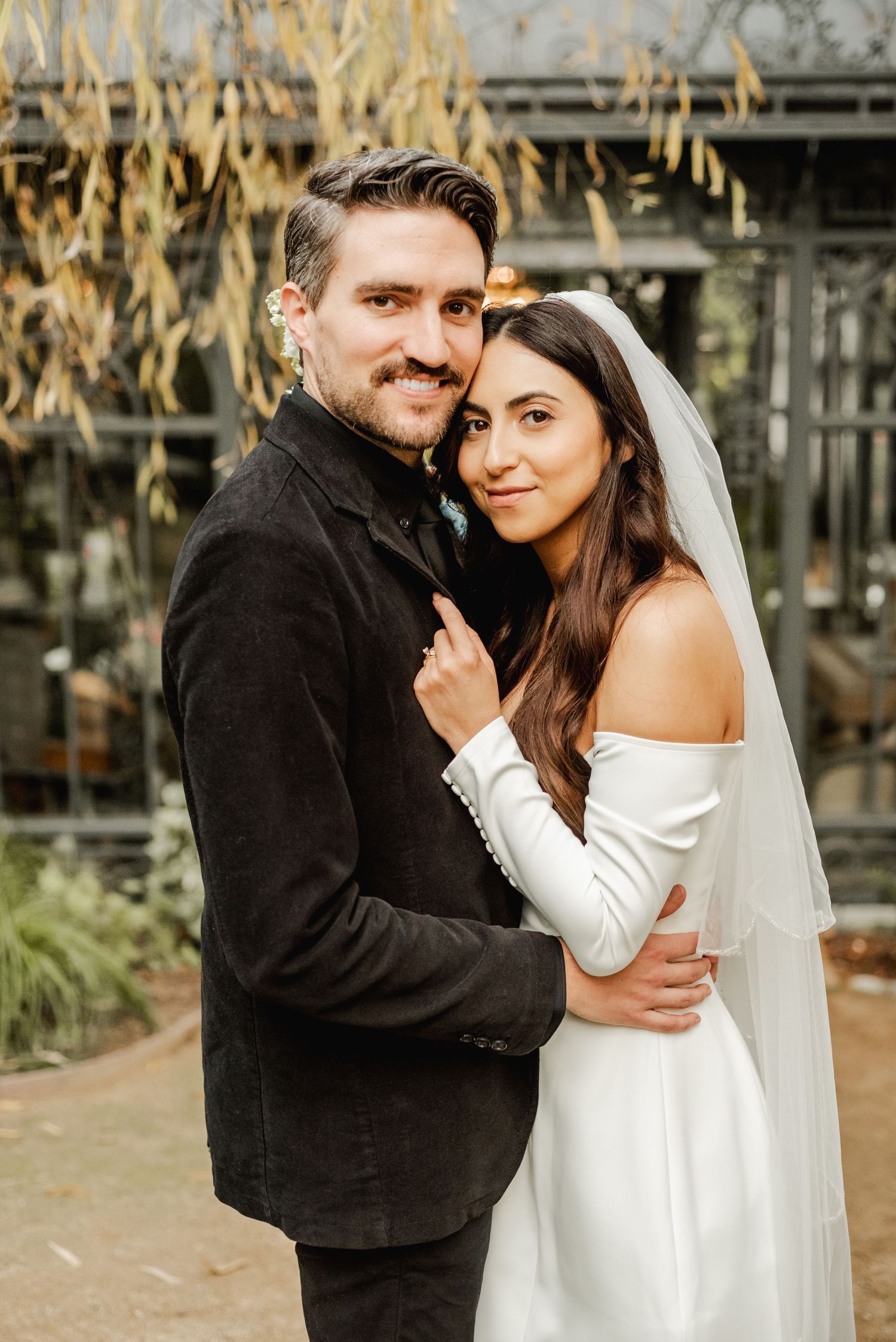 Cozy autumn wedding portraits with couple in white dress and black coat.
