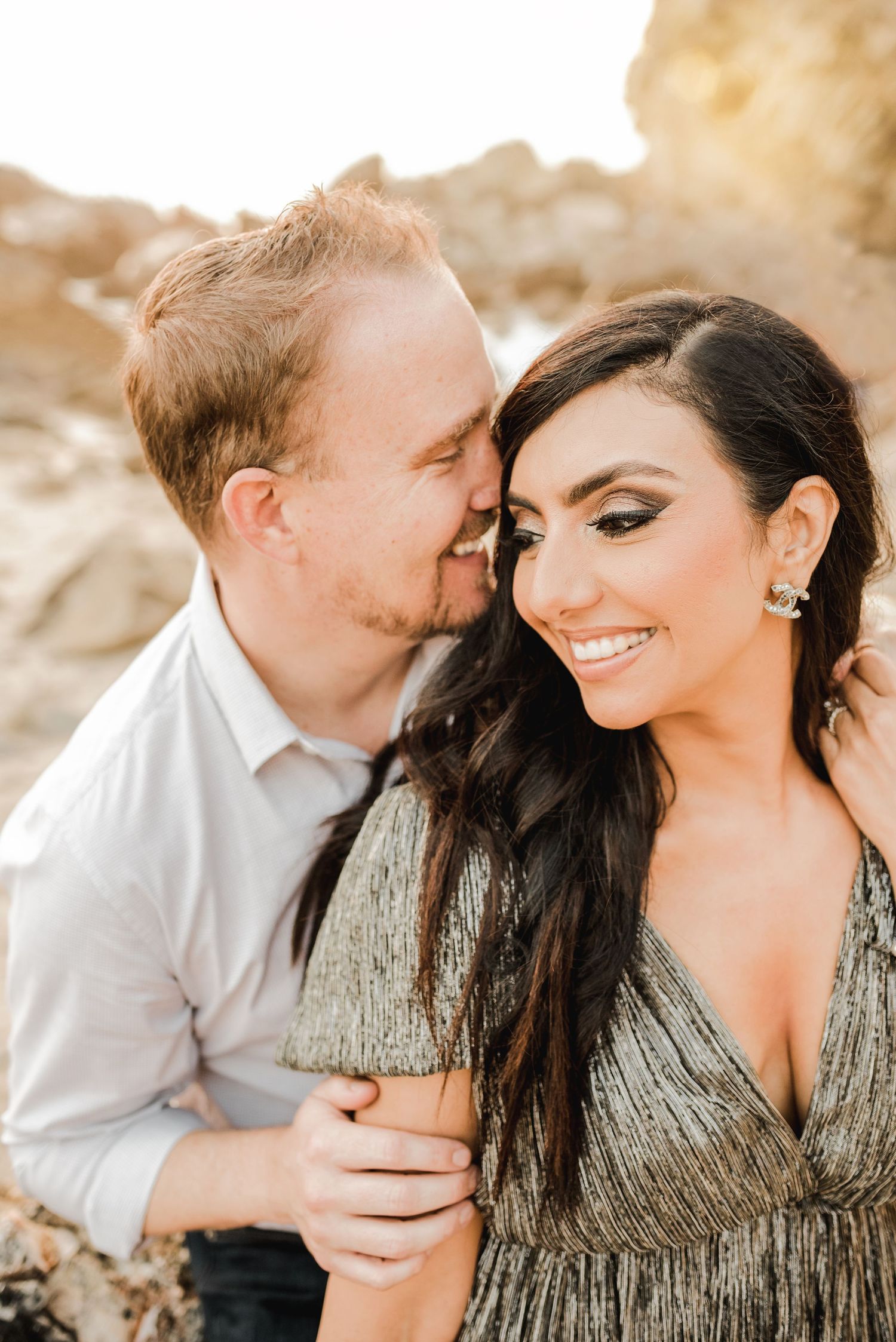 Intimate couple sharing tender moments against sunset backdrop.
