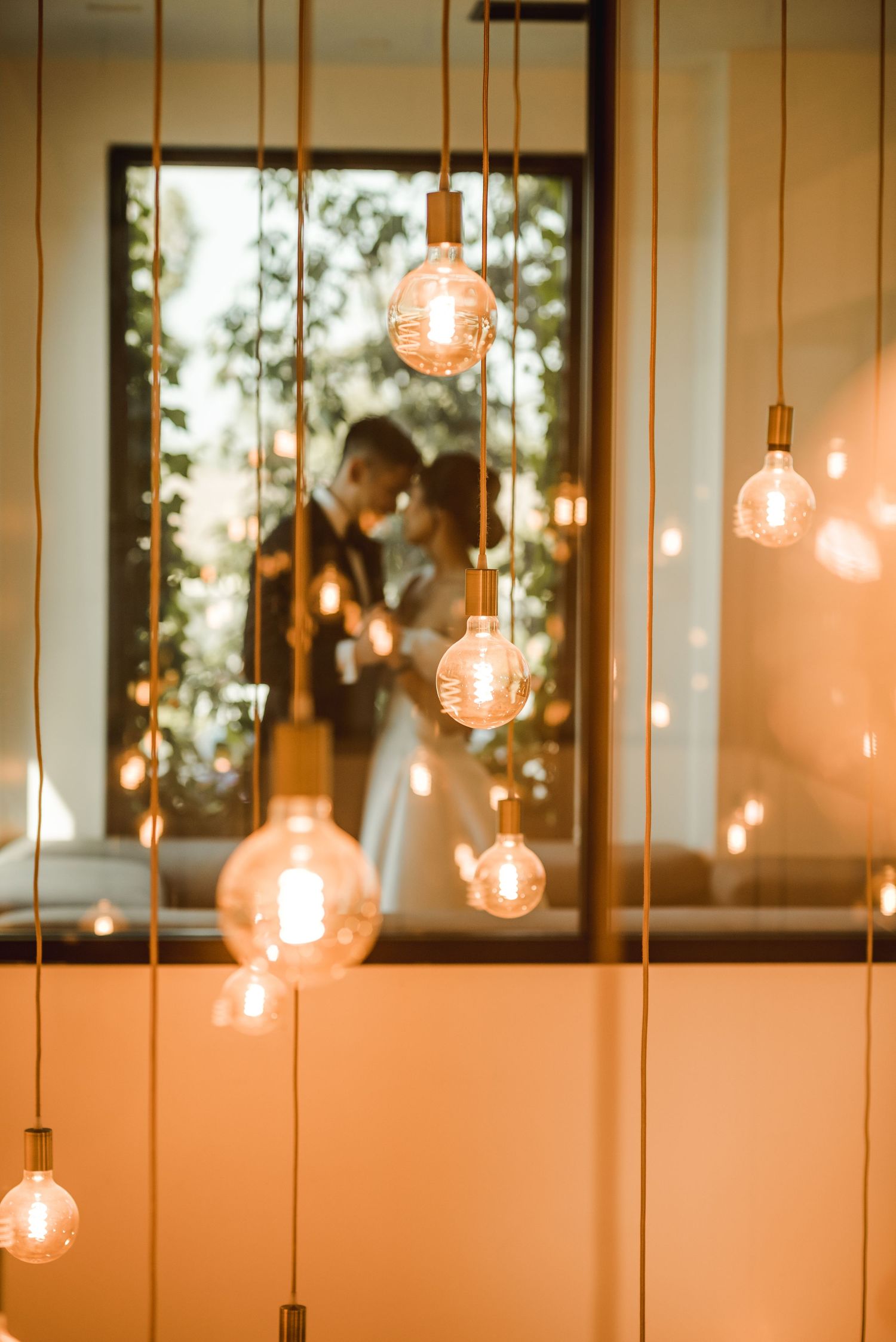 Hanging Edison bulb lights create a romantic ambiance for a wedding scene.