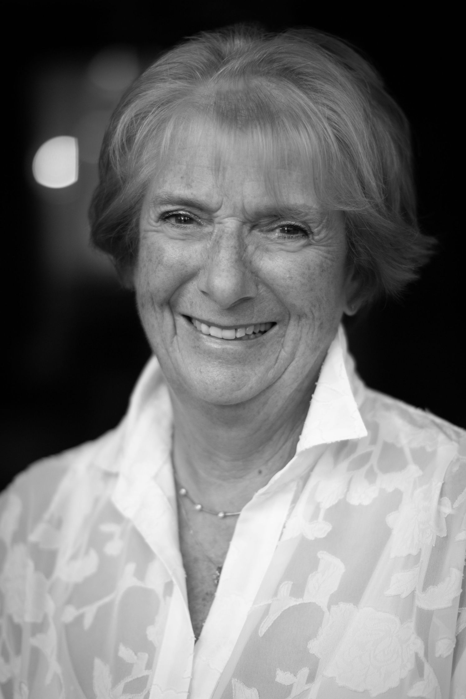 Black and white portrait image of a client from Brickendon Grange Golf Club, for their committee photos. Smiles  with a soft background.