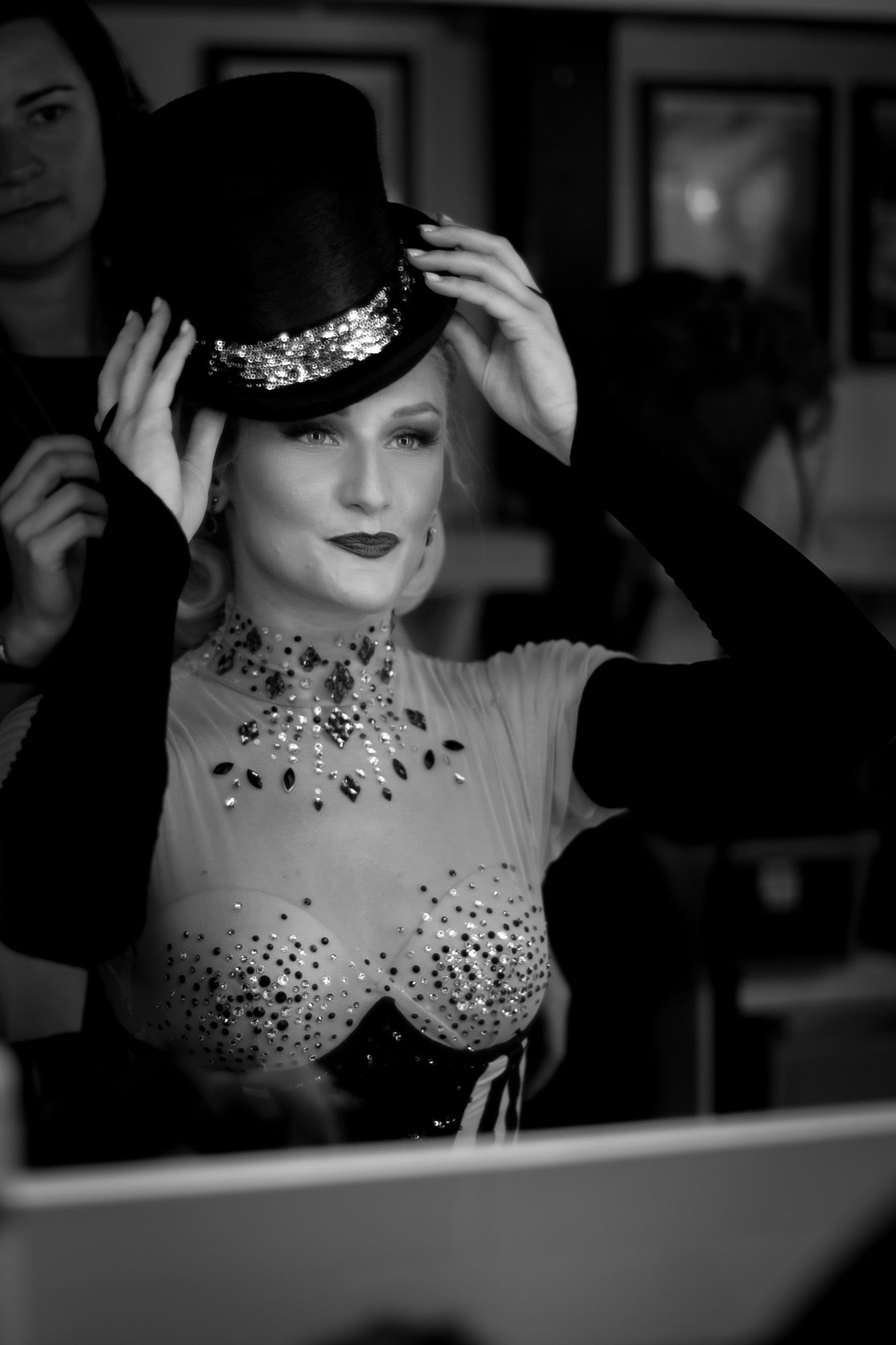 Black and white image of one of a performer at Moulin Rouge! The Musical in London. Backstage image of a performer during a wig change.