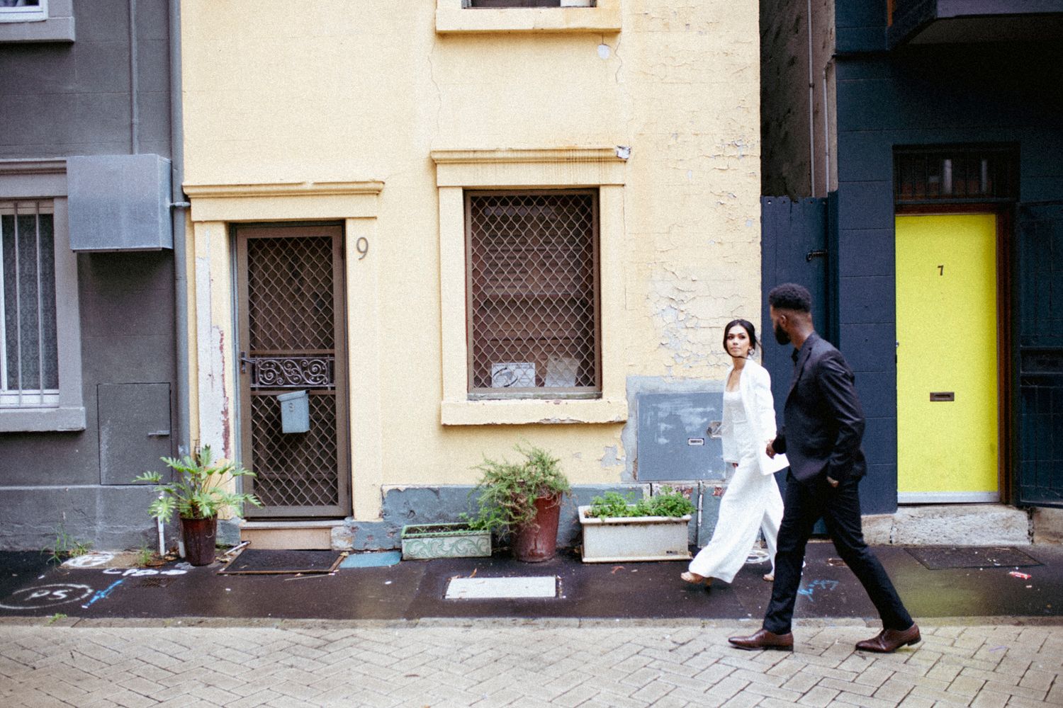 Candid street-style wedding photography of the couple walking through Sydney.