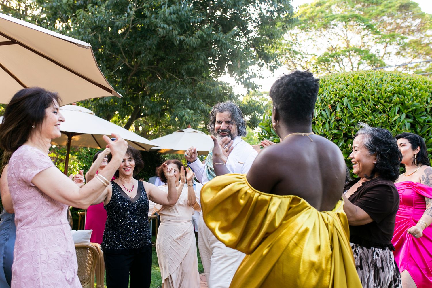 Sun-drenched portrait of the couple dancing through the manicured estate grounds.