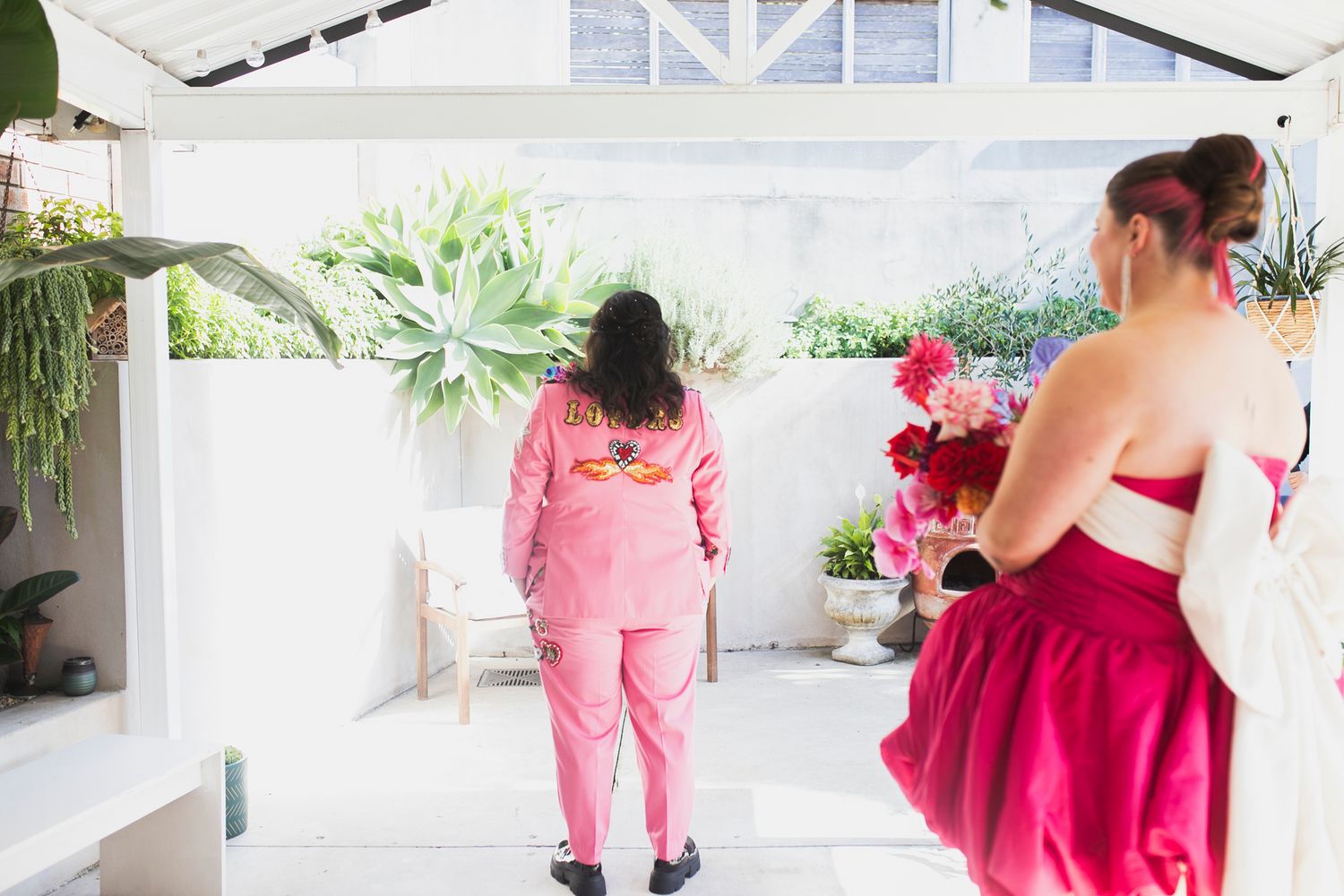 Tess and Amanda in stylish, editorial poses showing their Met Gala inspired wedding outfits.