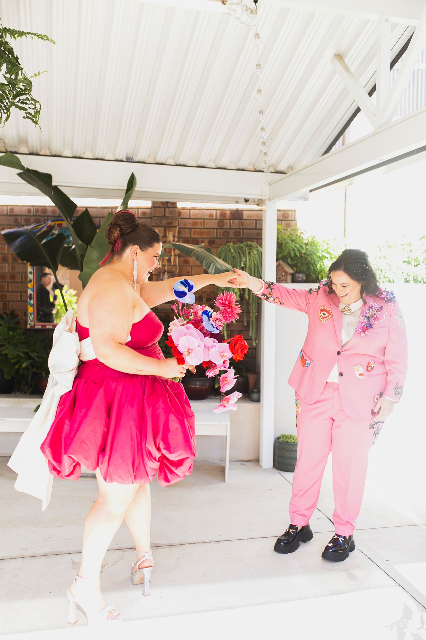 Tess and Amanda in stylish, editorial poses showing their Met Gala inspired wedding outfits.