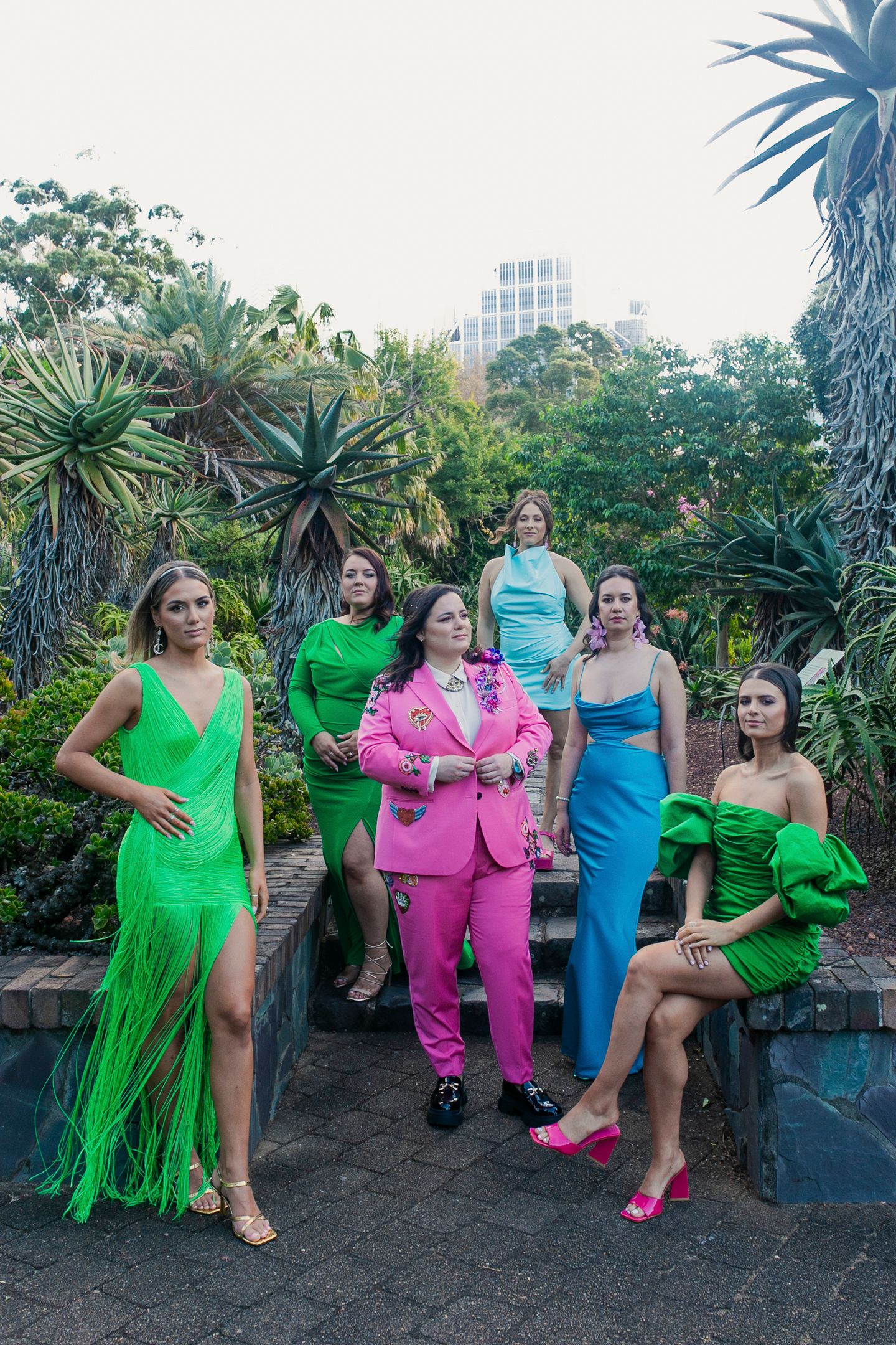 Vibrant, high-fashion group photo of the VIP bridal party on the steps of the Sydney Botanical Gardens.