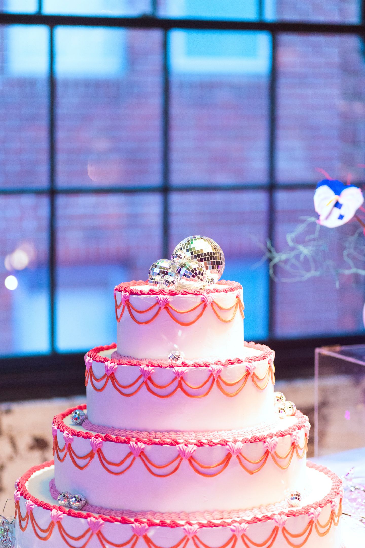 Detail shot of a colourful piñata wedding cake and custom love-heart vases.