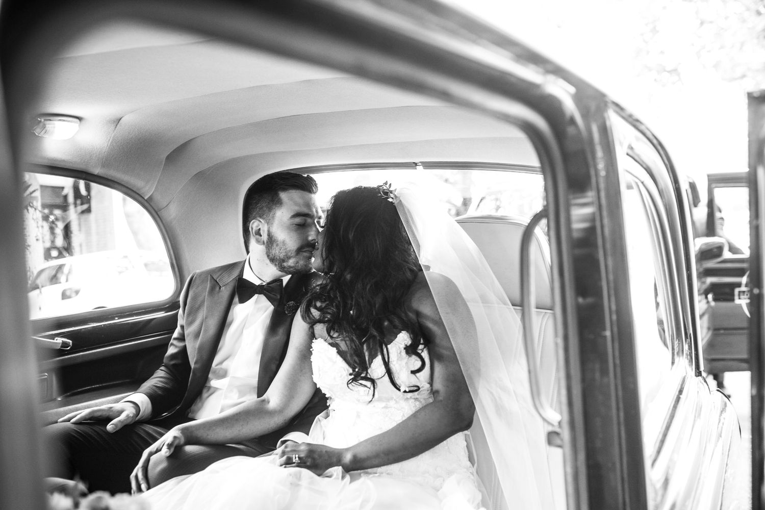 Tom and Ruth arriving in a classic vintage English taxi cab to their black-tie wedding.