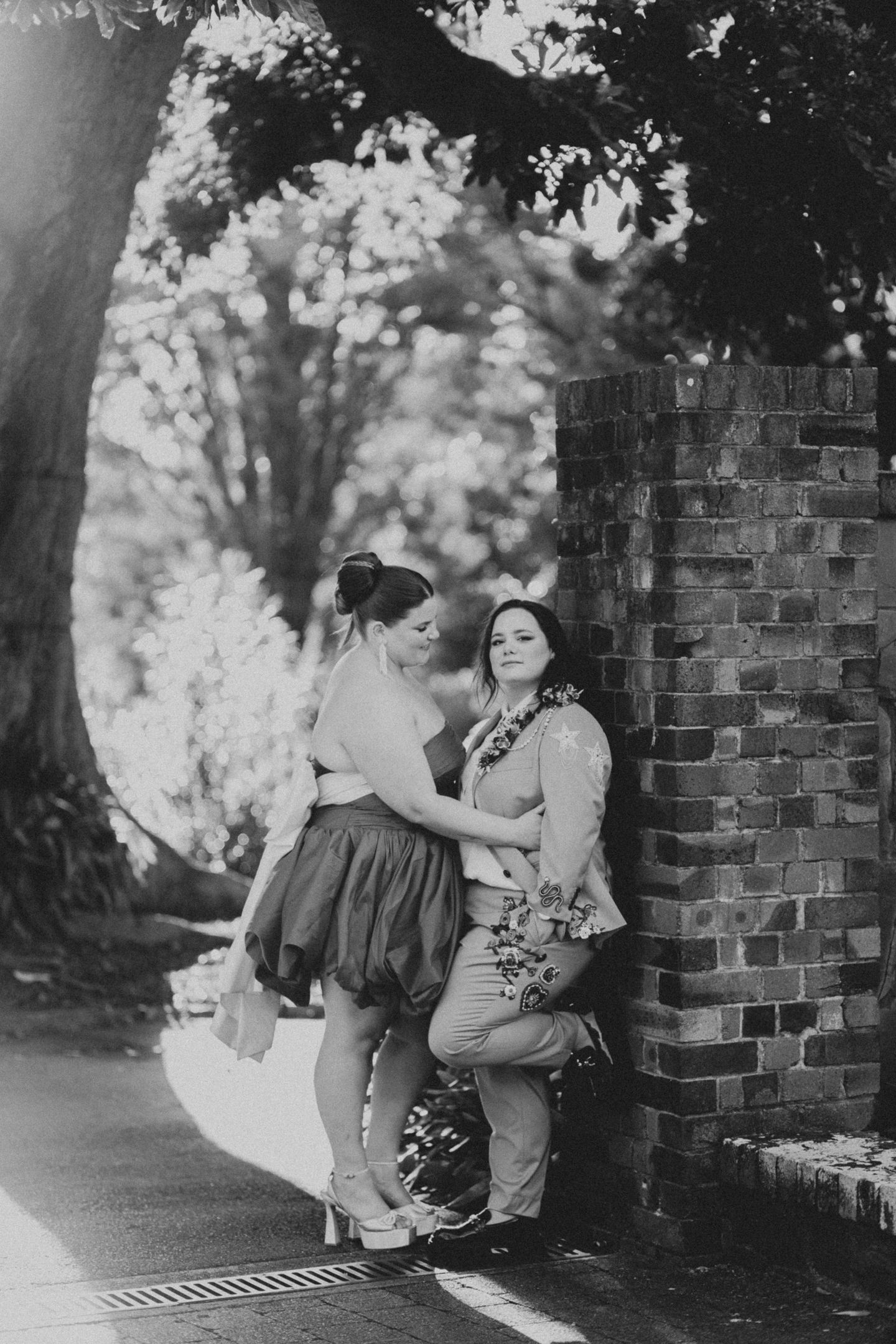 Artistic portrait of the brides embracing in the Royal Botanic Garden Sydney by Koco Weddings.