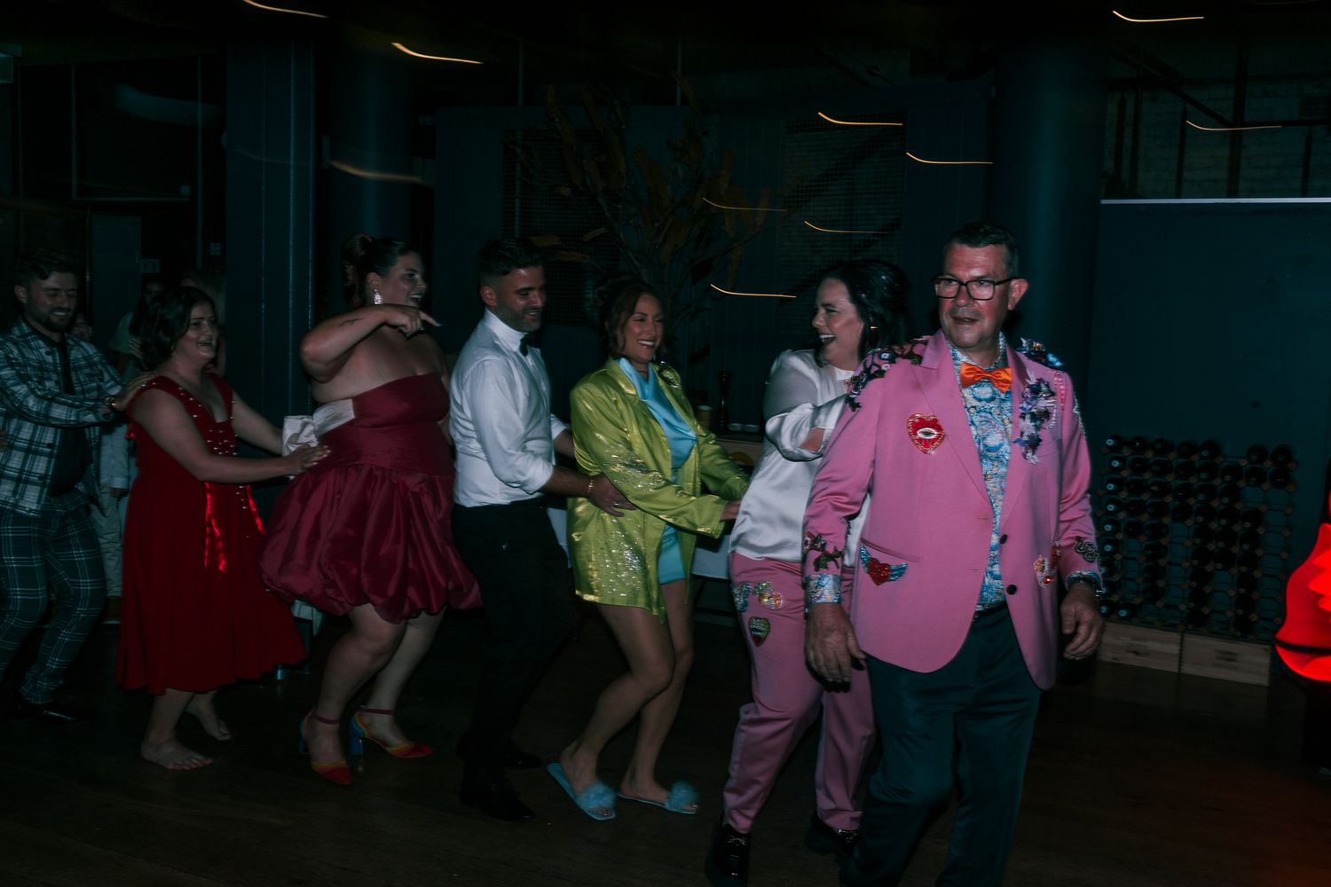 Guests dressed in extravagant Met Gala theme attire celebrating on the dance floor.