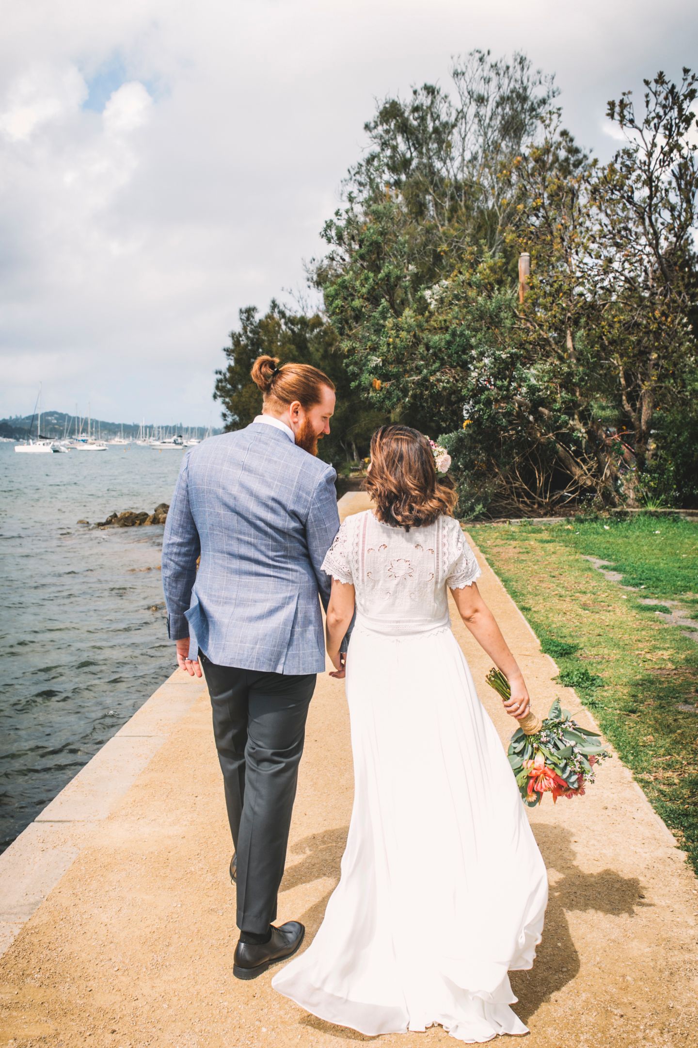 Janel and Alex sharing a moment on the jetty with expansive Northern Beaches water views.