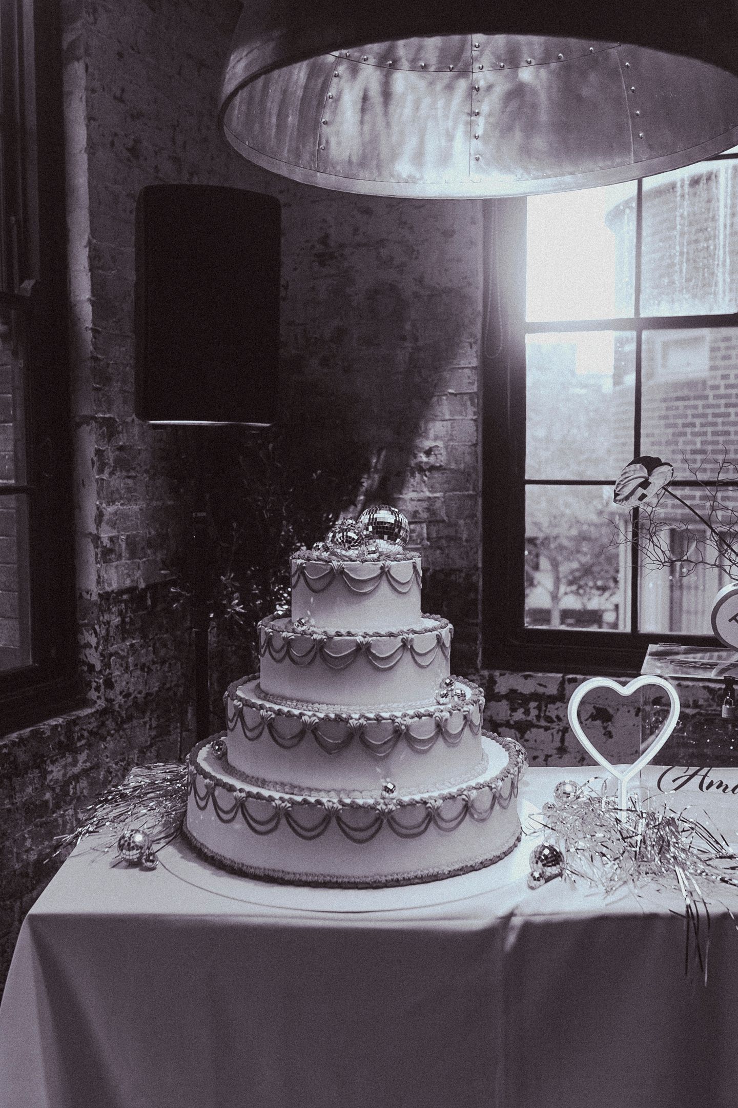 Detail shot of a colourful piñata wedding cake and custom love-heart vases.