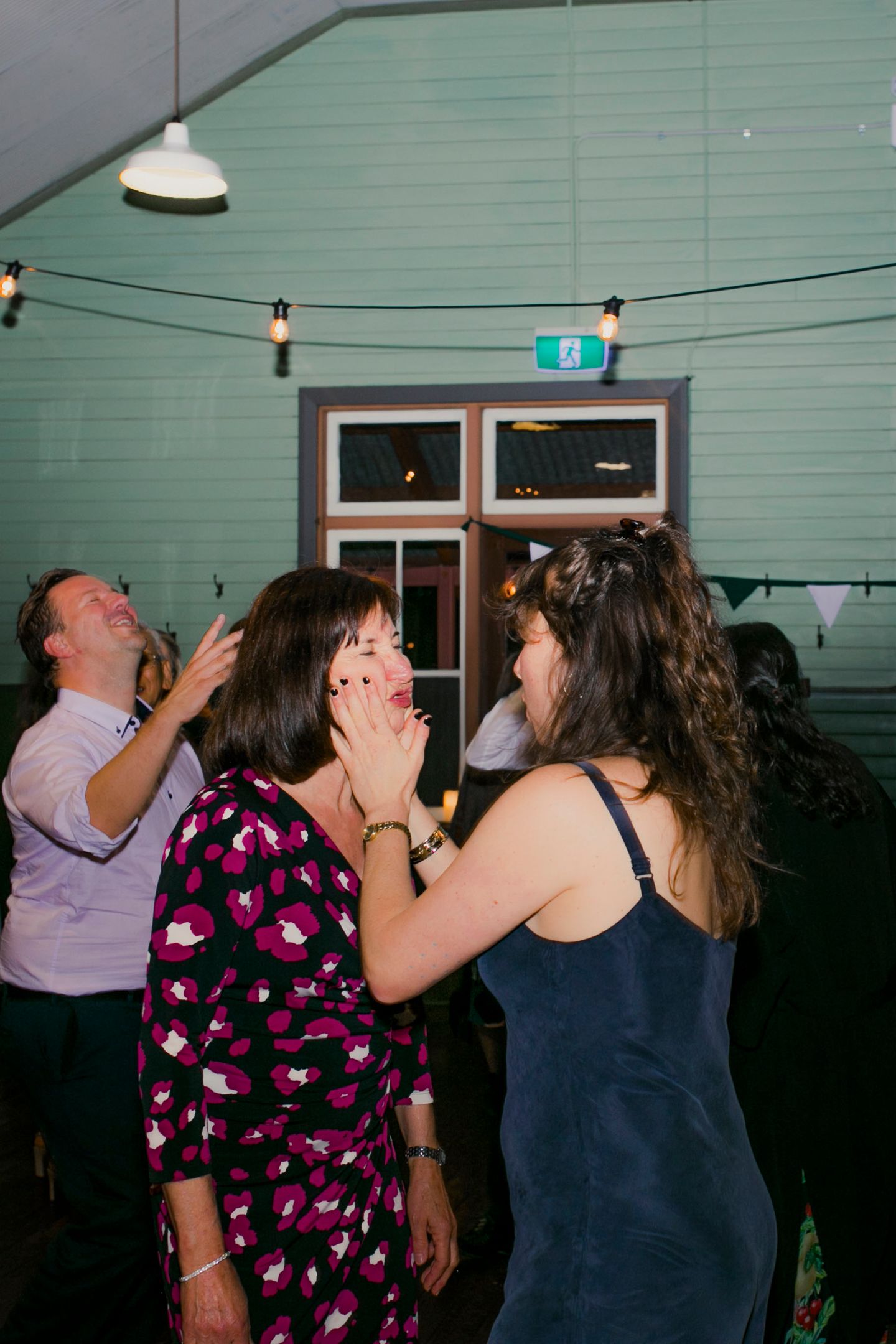Guests dancing under warm market lights at a rustic Q Station reception.