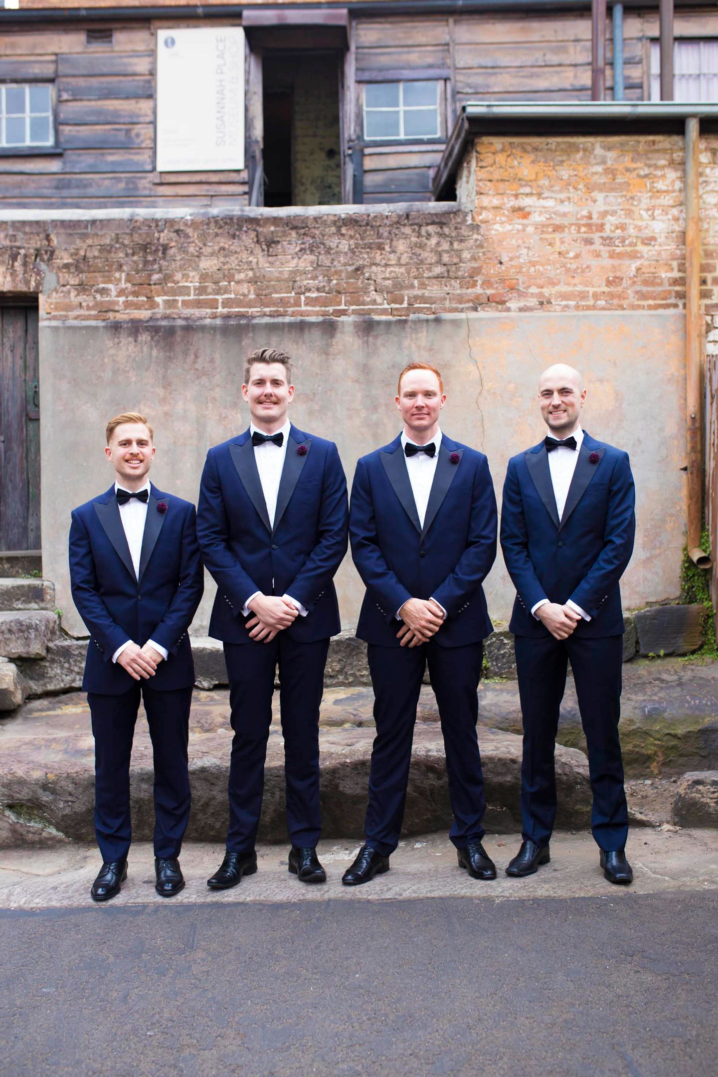 Black-tie groomsmen portrait showing fine tailoring by The Suit Shop and Rembrandt details.