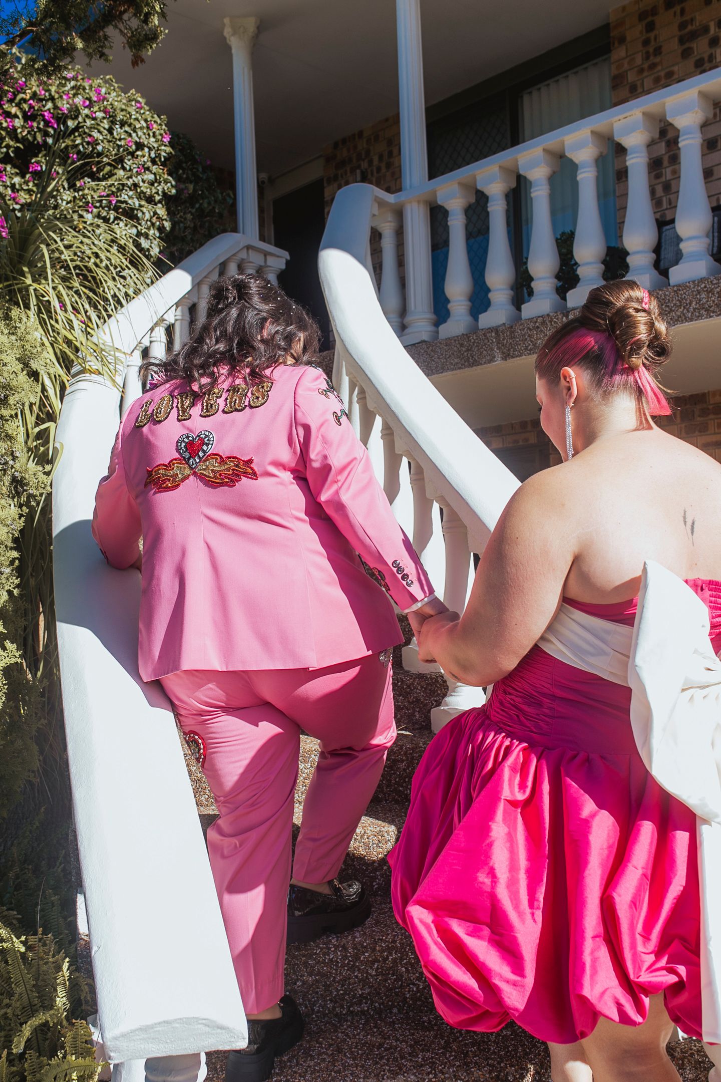 Tess and Amanda in stylish, editorial poses showing their Met Gala inspired wedding outfits.