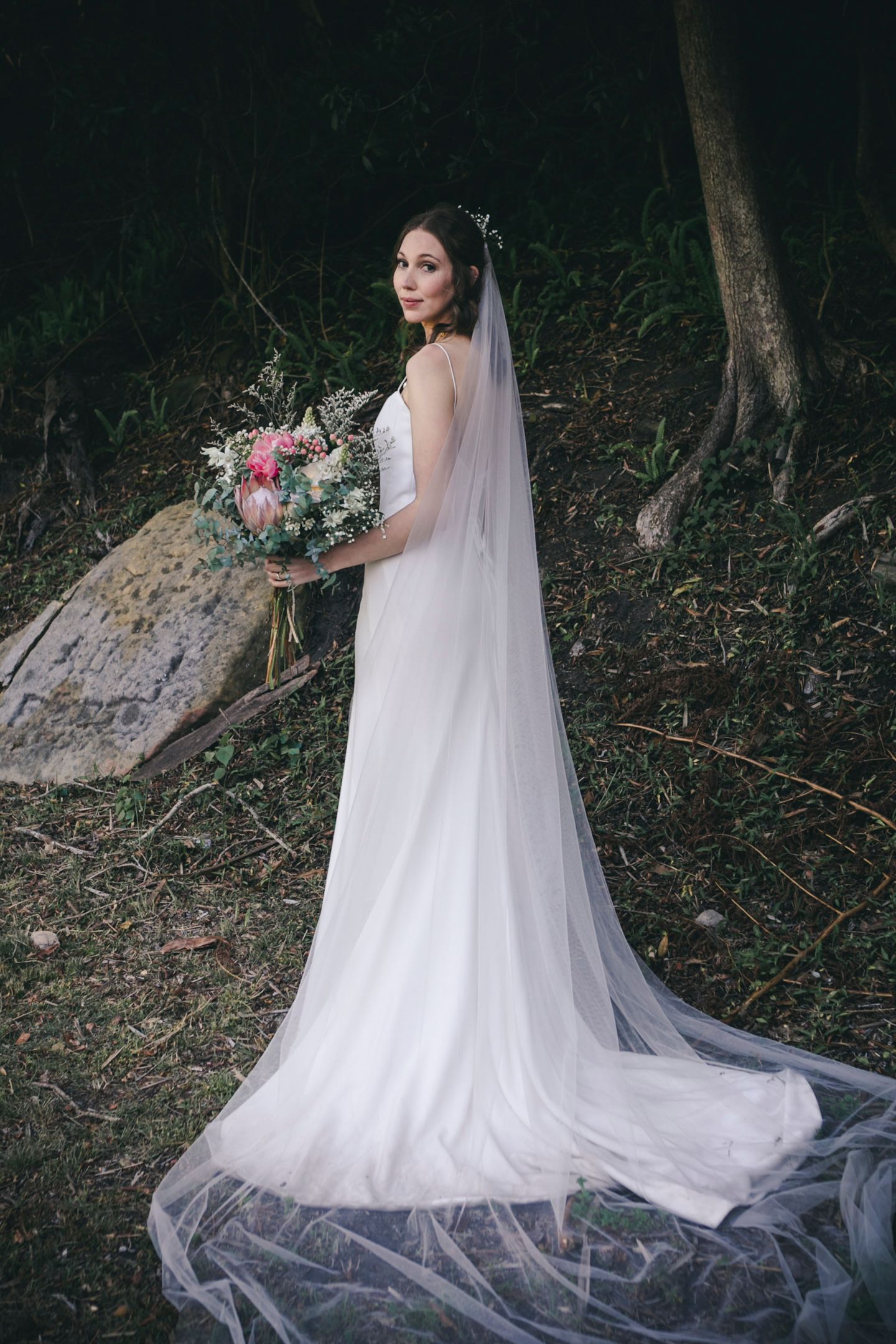 Editorial portrait of the bride in The Bare Faced Bride gown against rugged sandstone.