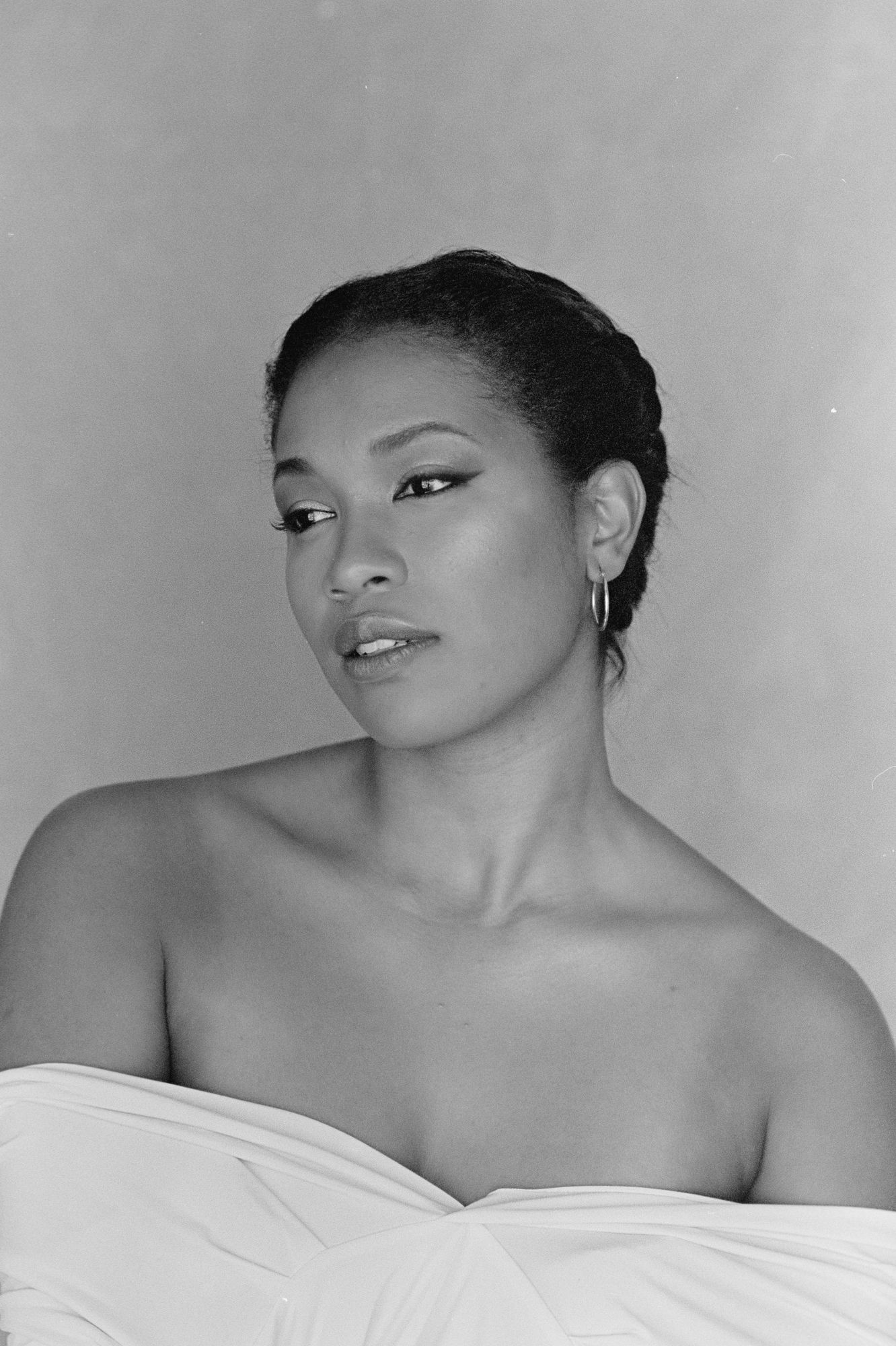 Black and white artistic portrait series showing a person posing against a light background with dramatic shadows.