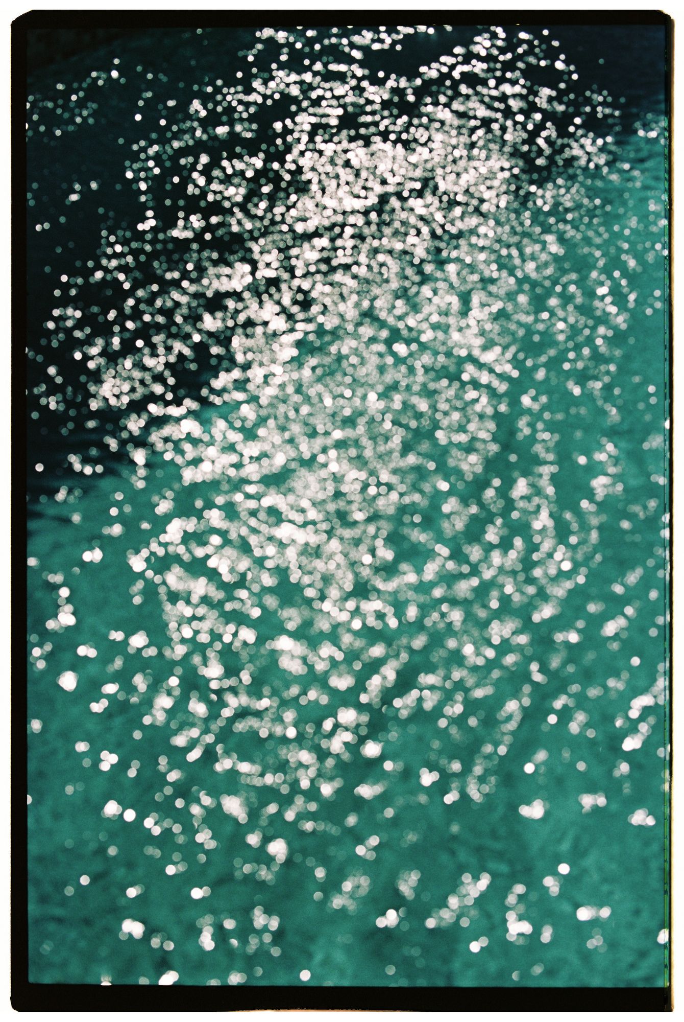 Sparkling white dots scattered across a deep teal background create a mesmerizing bokeh effect in multiple frames.