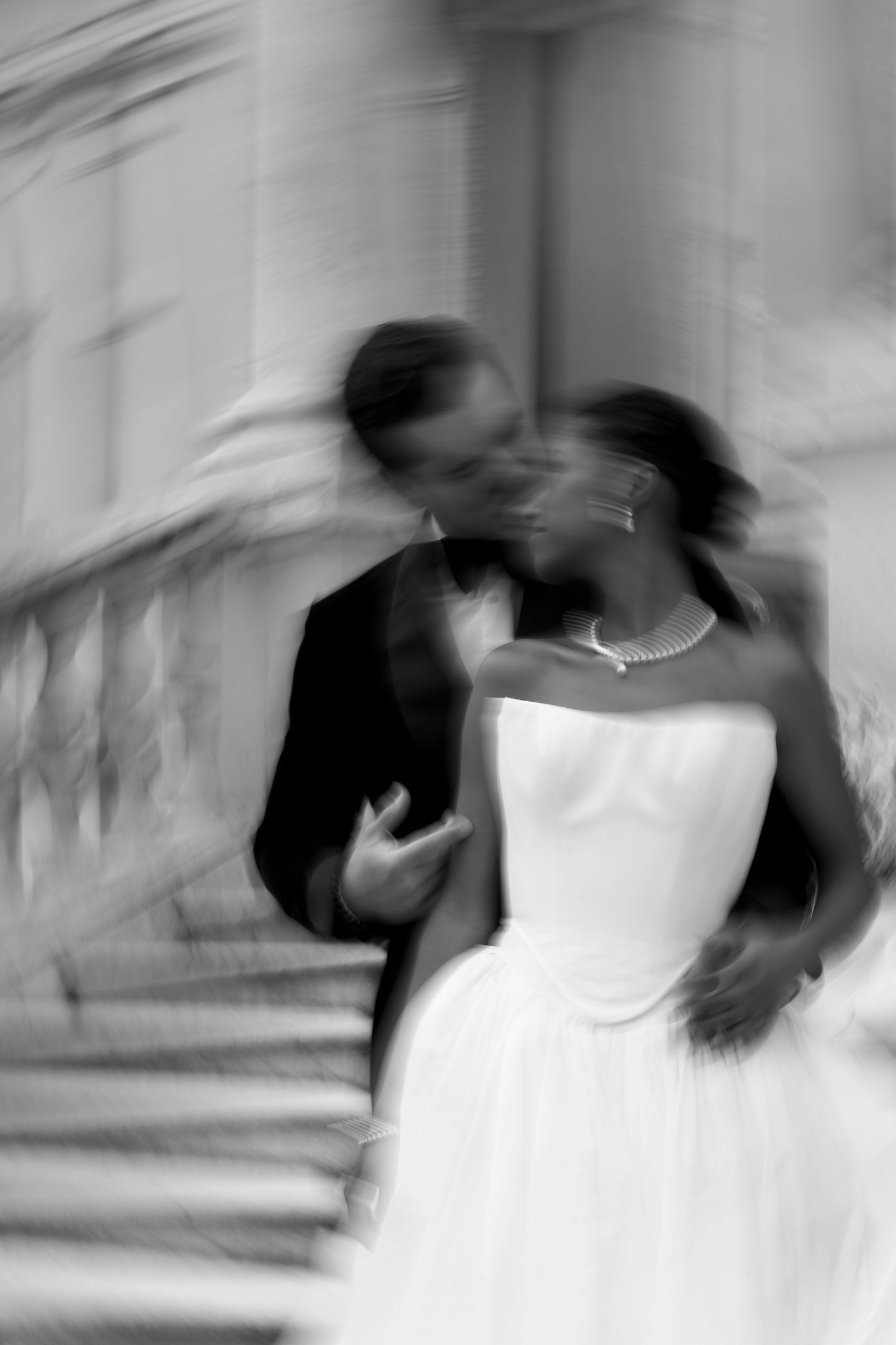Black and white photo of an African American bride and groom sharing a romantic kiss on wedding day.
