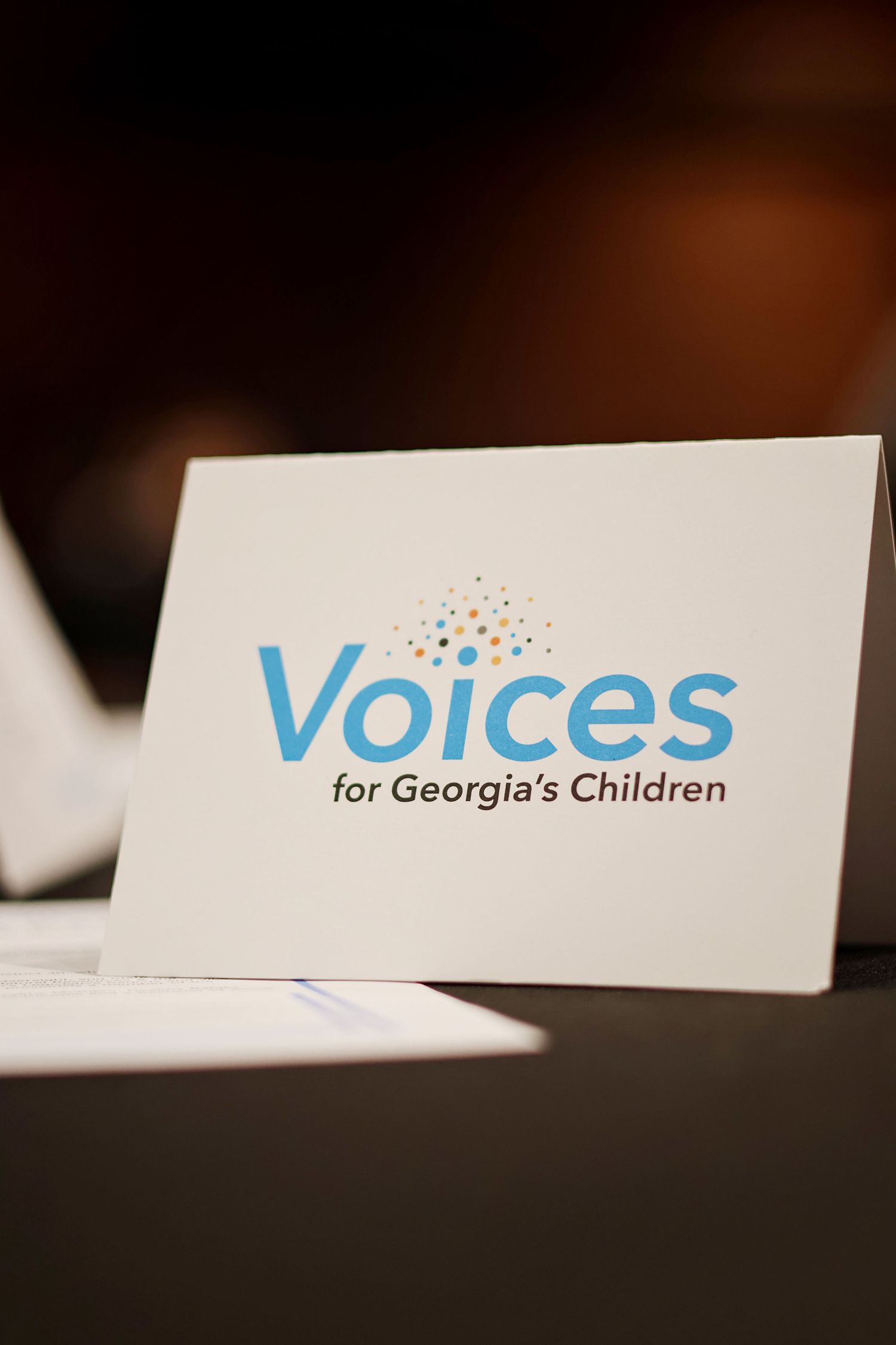 White tent card displaying the Voices for Georgia's Children logo in blue text at a formal event.