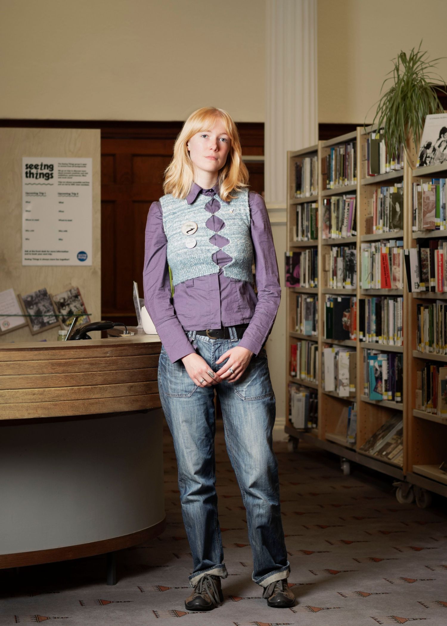 A woman standing at the front desk of a library