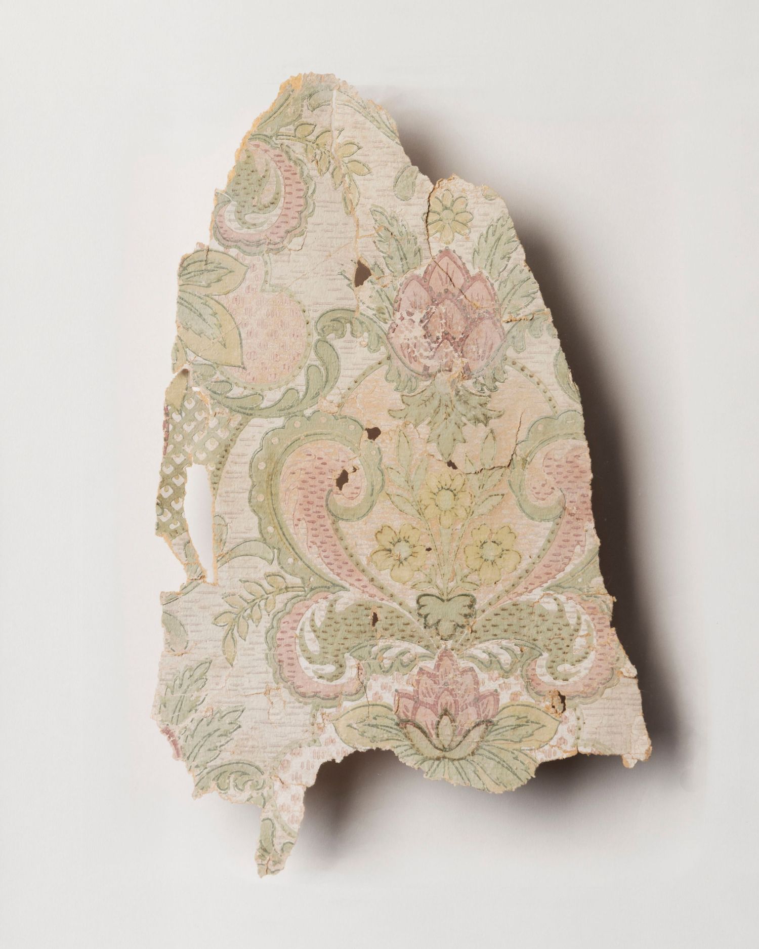 A fragment of wallpaper; cream, pink and green with a flowery pattern
