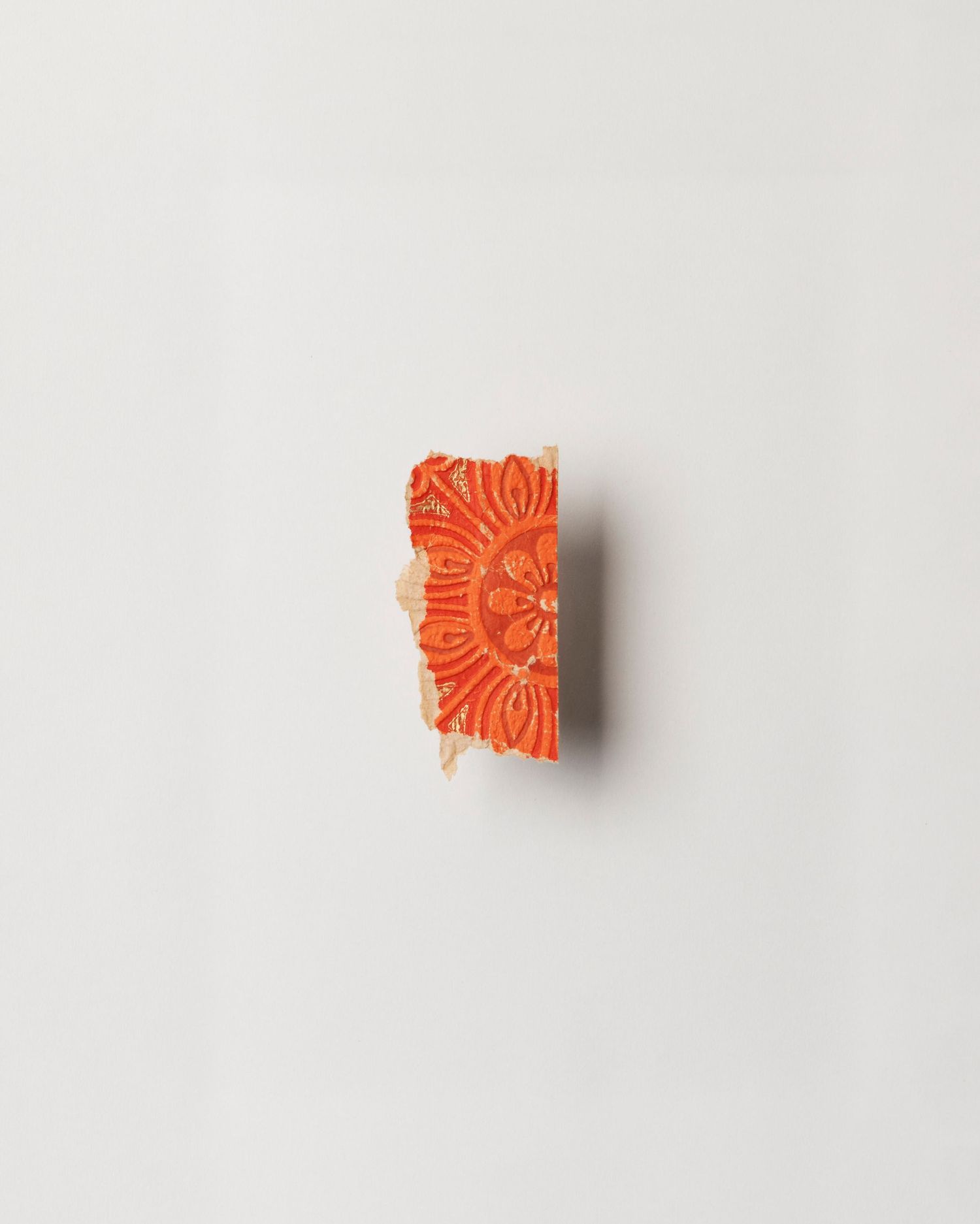 A fragment of wallpaper; orange with a flower pattern