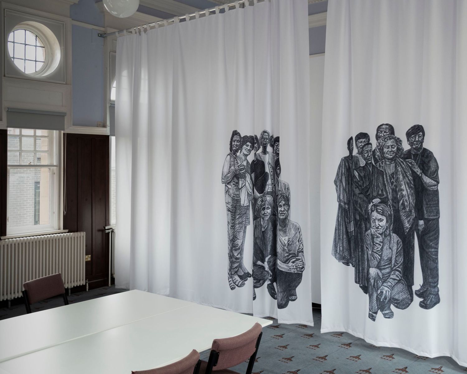 A curtain with a black line drawing of women of historical significance