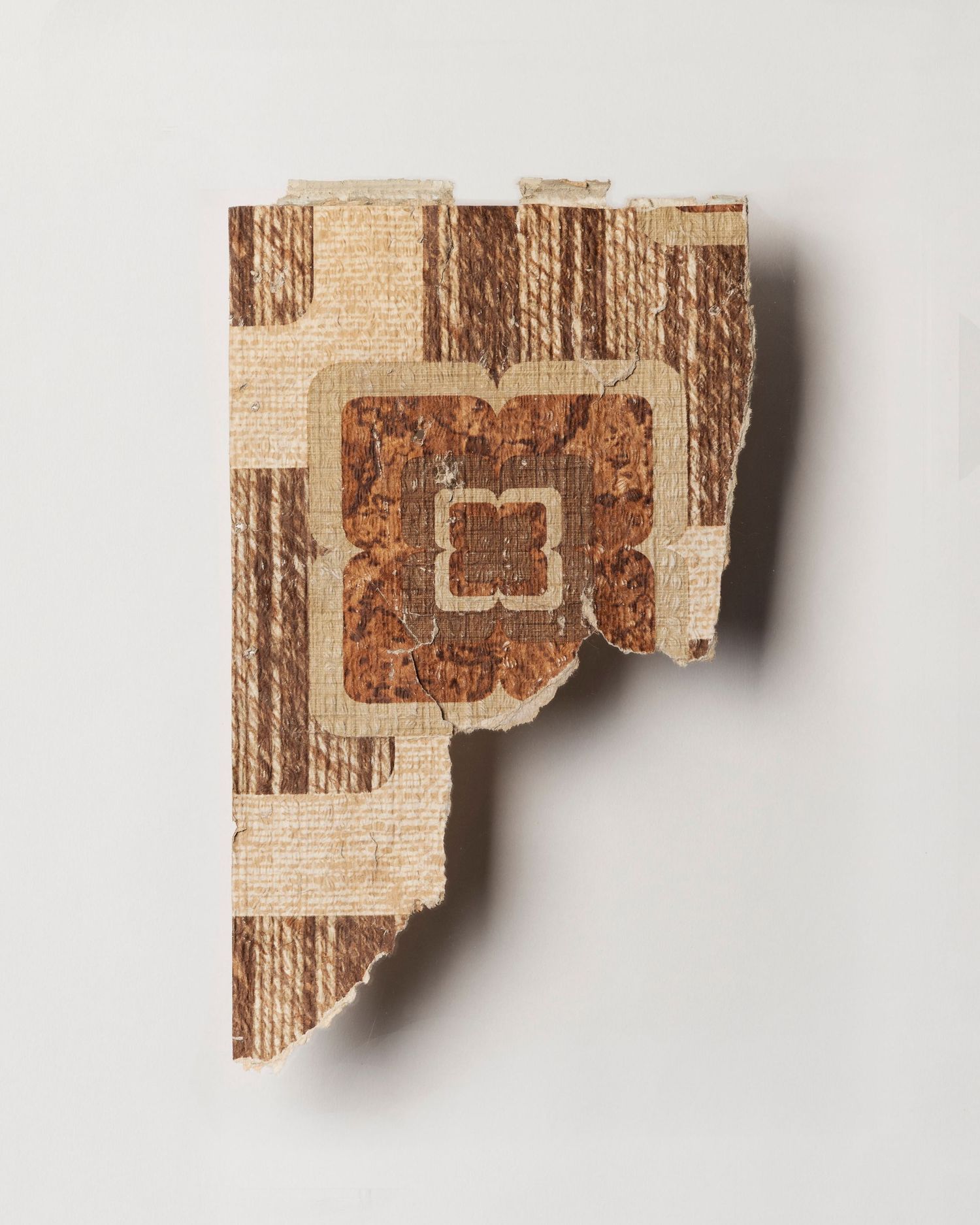 A fragment of wallpaper; brown and cream geometric shapes