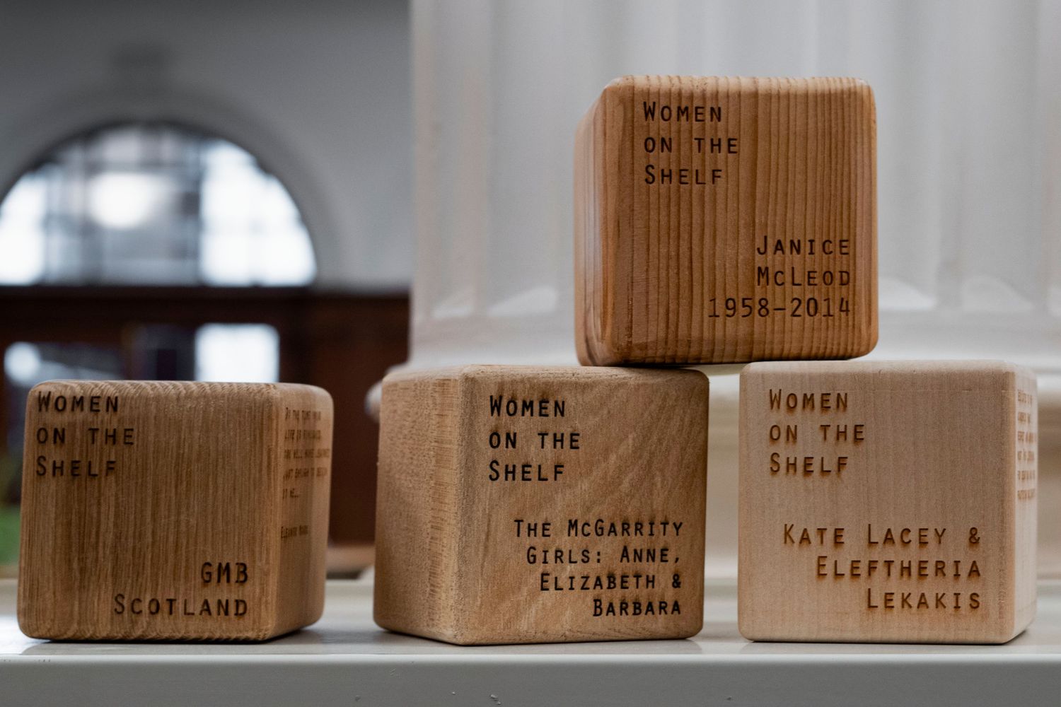 Four wooden blocks with names and dedications carved into them