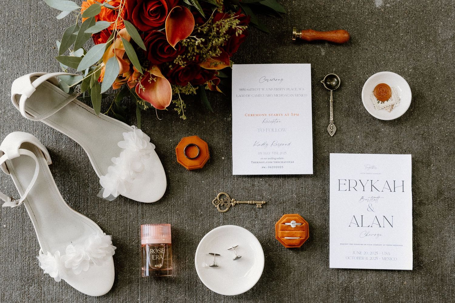 Flat lay of wedding details including white heels, invitation suite for Erykah and Alan, and florals.
