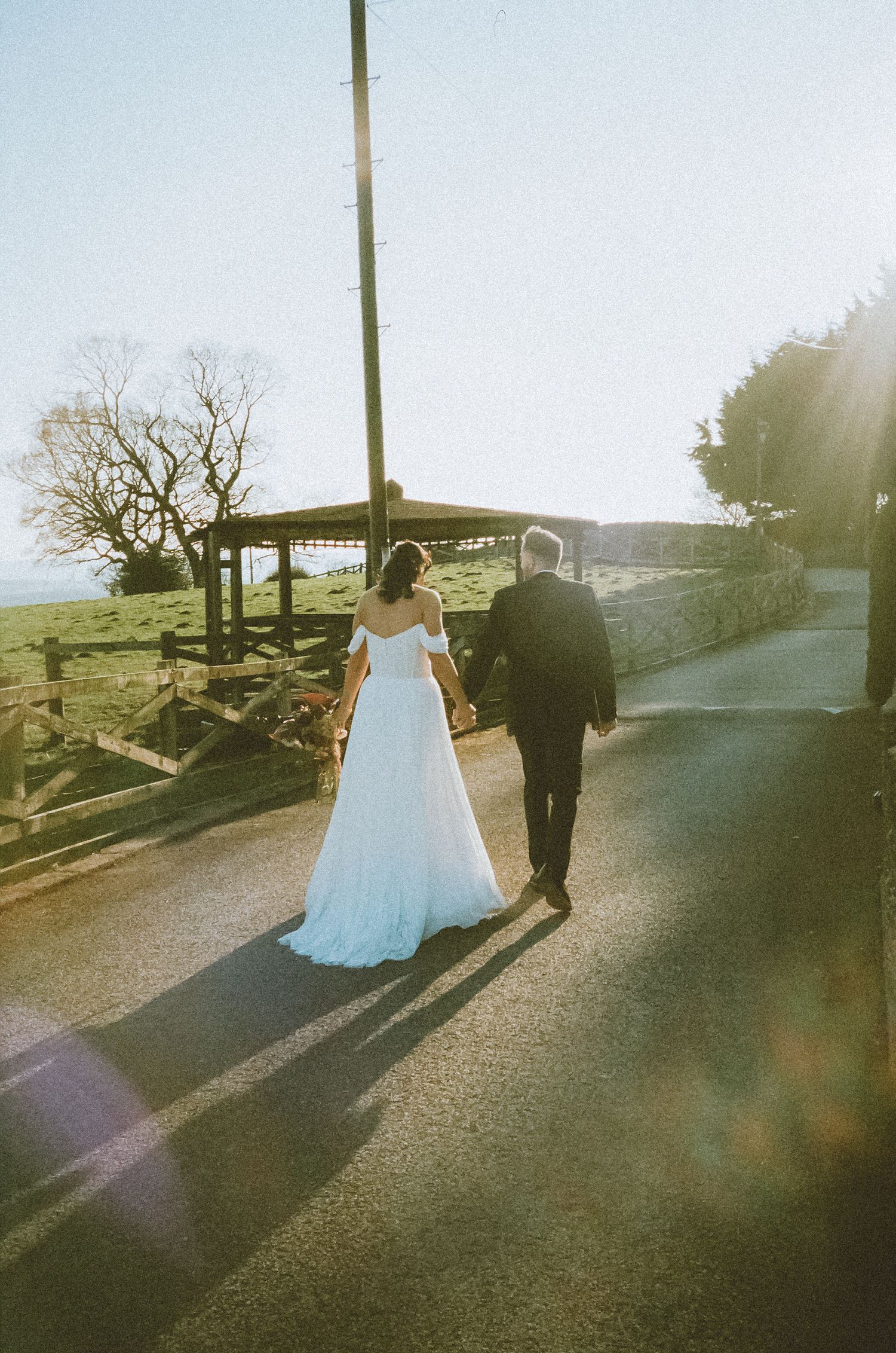 35mm film photo of bride and groom walking during golden hour on their wedding day