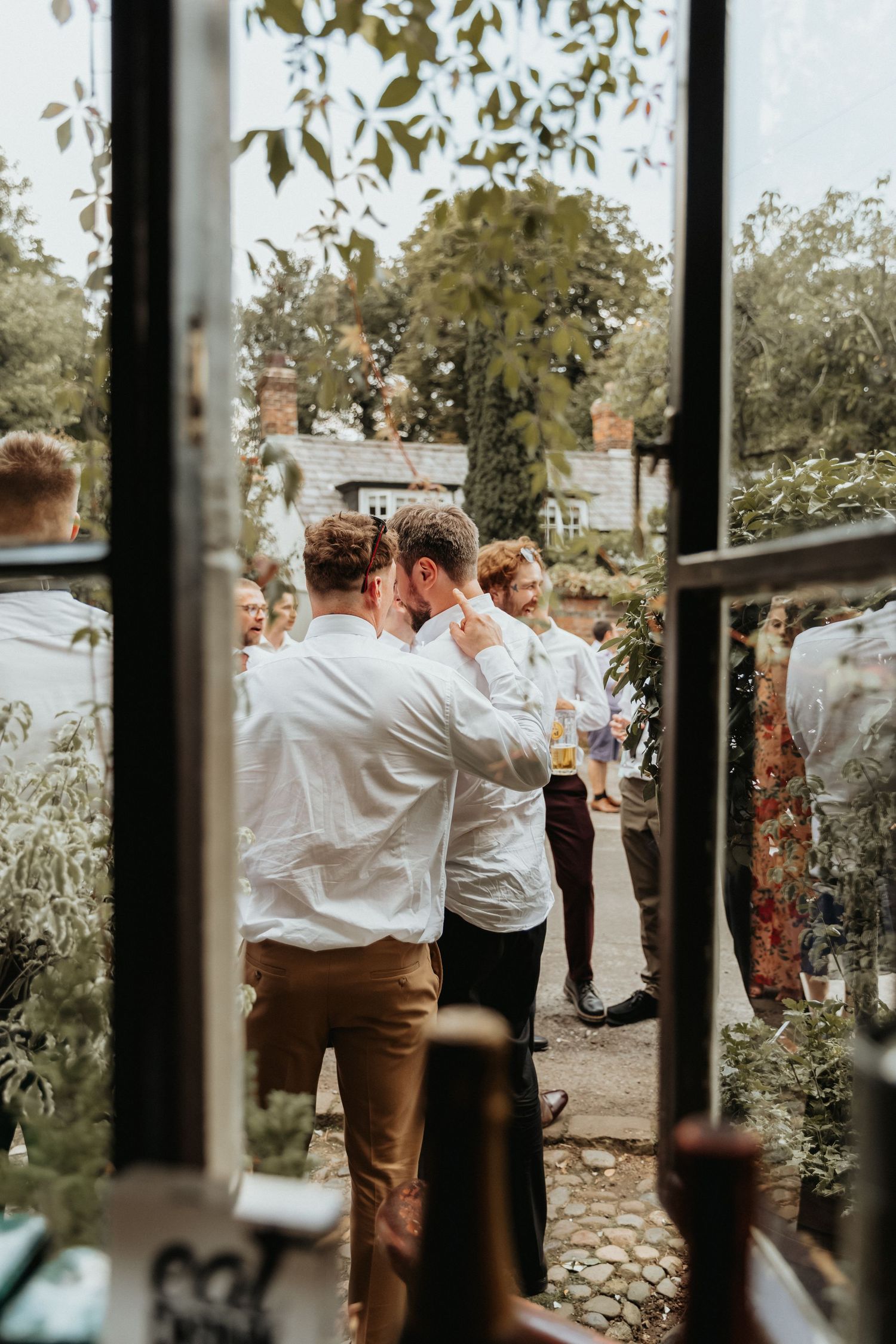 Wedding guests enjoying drinks through the window