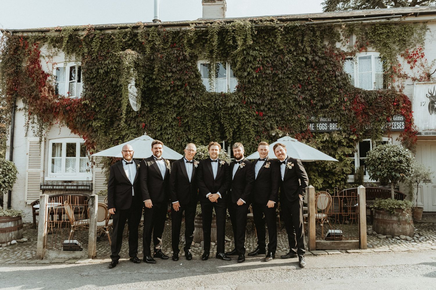 Groom and groomsmen standing in line outside the Roebuck Inn Cheshire
